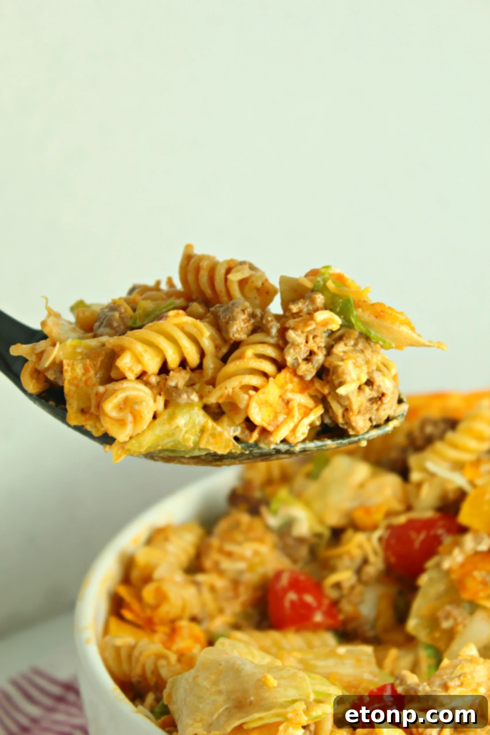 A vibrant, overflowing bowl of Doritos Locos Taco Pasta Salad, emphasizing its appeal as a family favorite and a huge hit for any event.