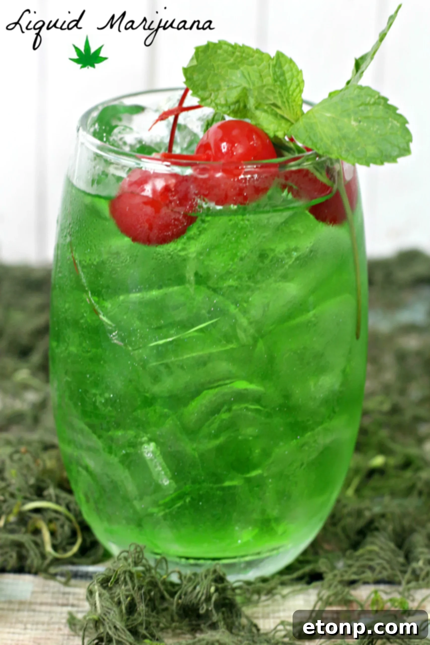 A refreshing glass of Liquid Marijuana Cocktail garnished with green apple slices and a lime wedge