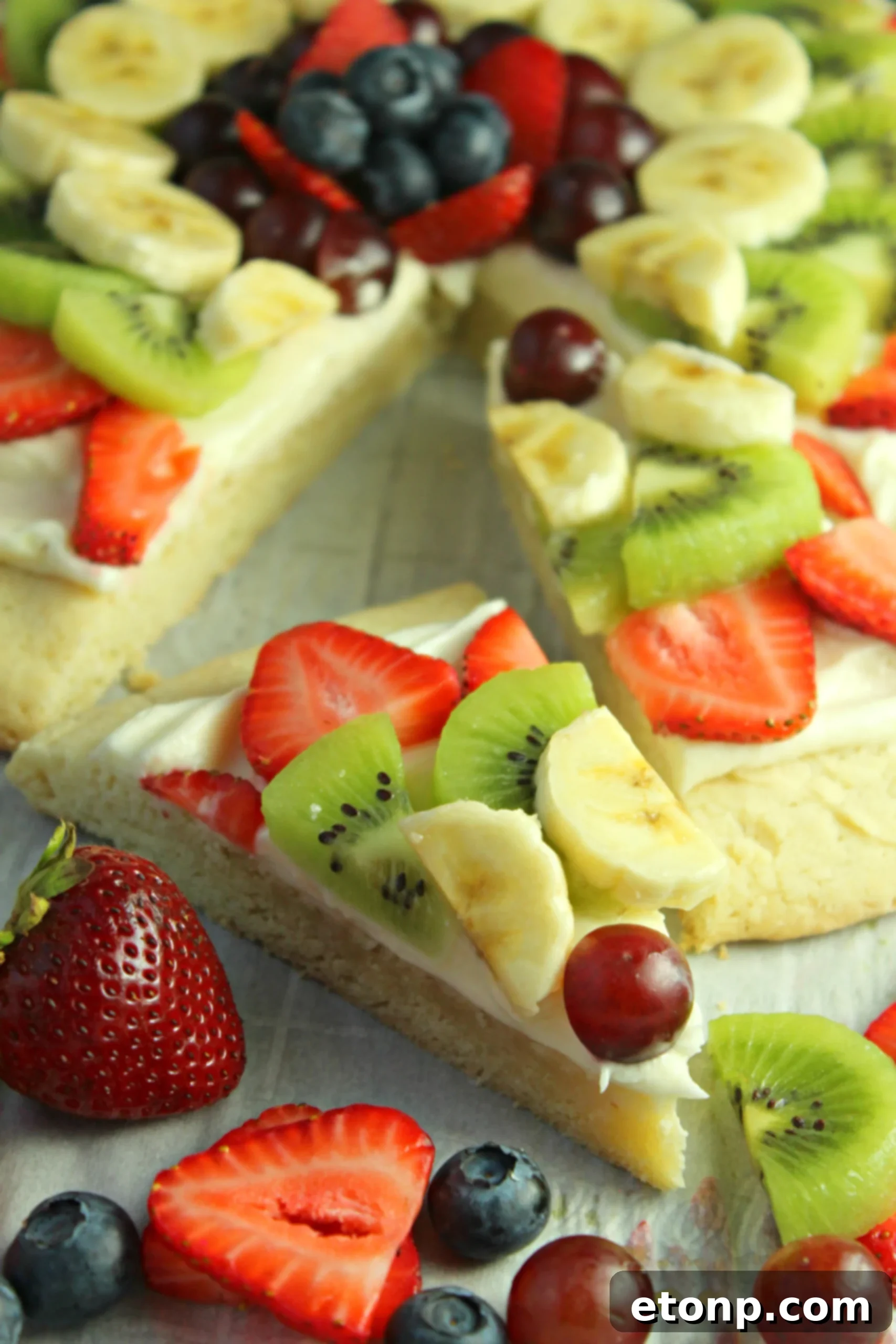 Sugar cookie dough pressed into a pizza pan, ready to be baked into a fruit pizza crust.