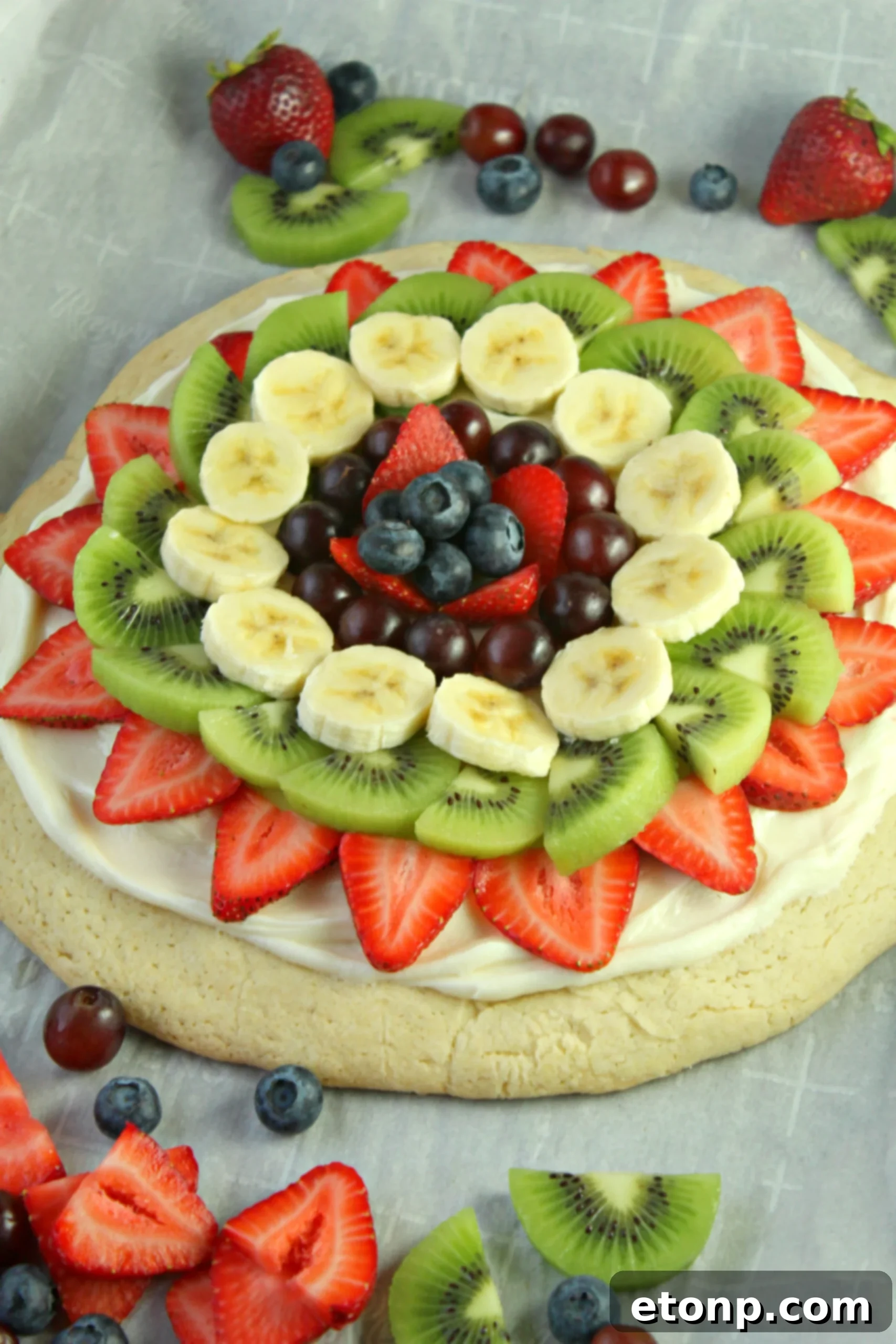 Baked sugar cookie crust cooling in a pizza pan, ready for frosting and fruit.