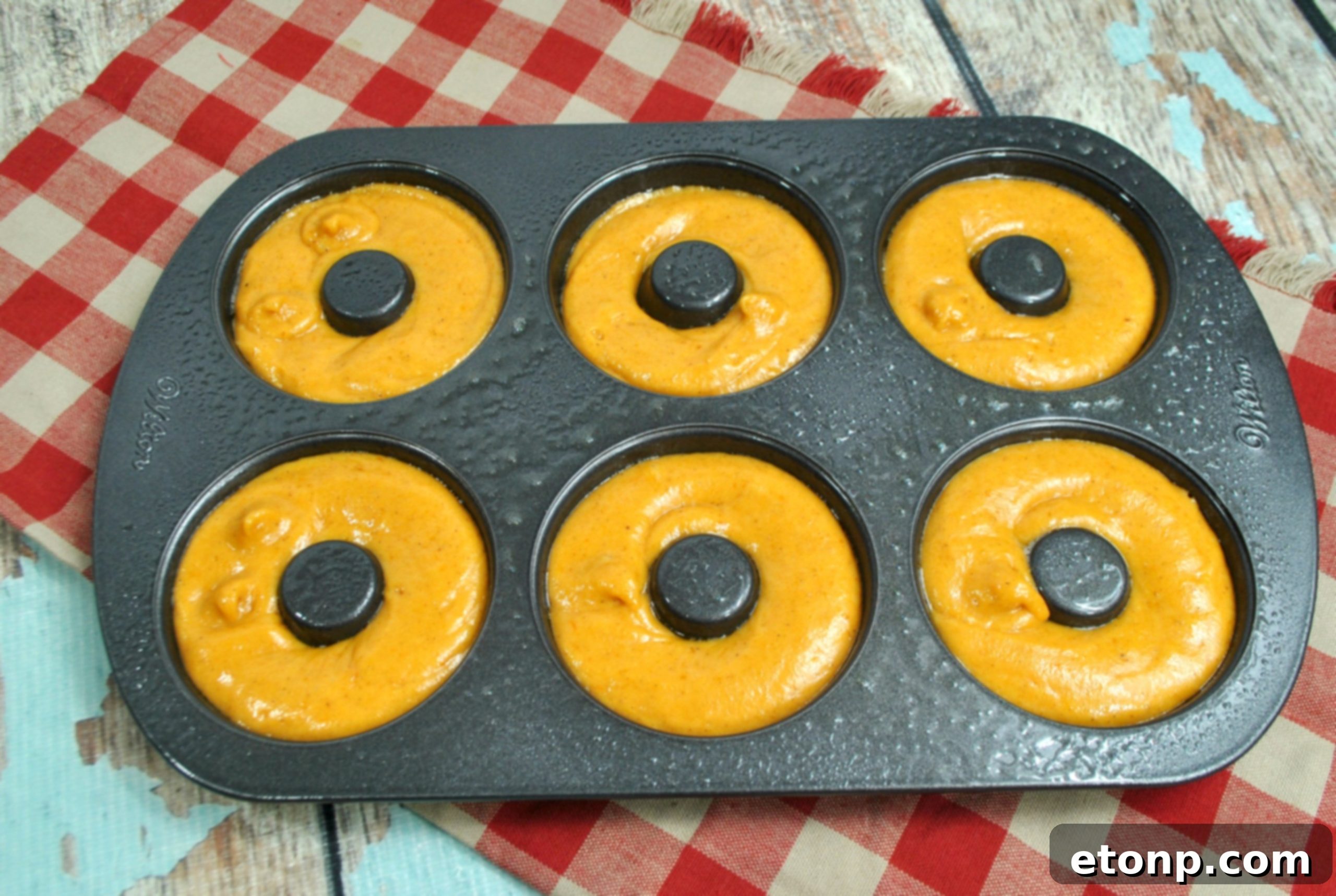 Freshly baked pumpkin donuts cooling on a wire rack