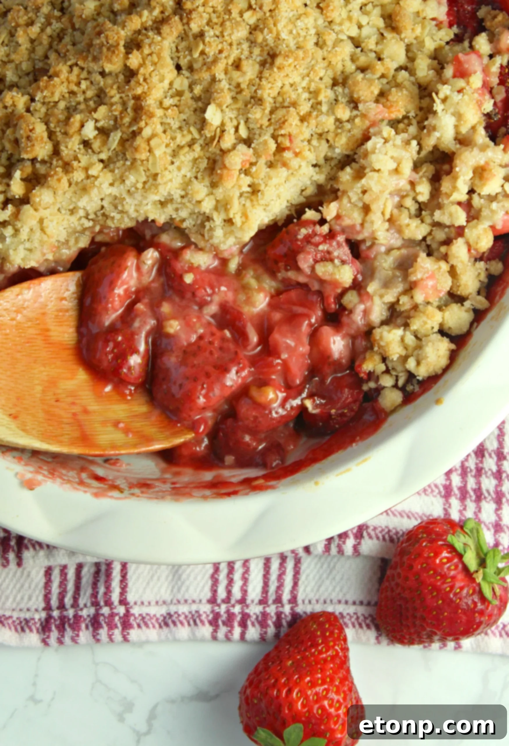 Final plated Fresh Strawberry Crisp with a spoonful