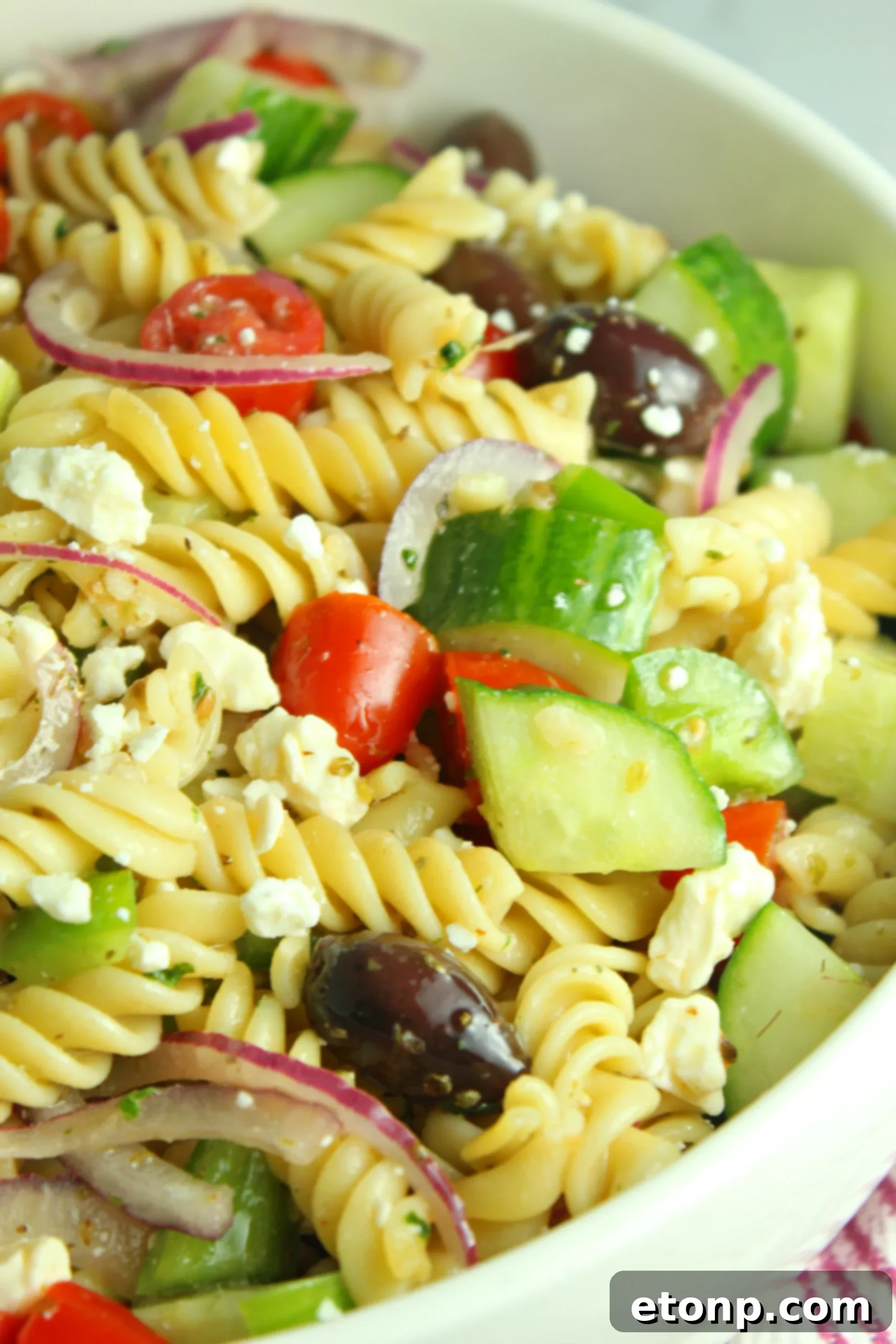 A bowl of cooked rotini pasta, ready to be cooled and mixed into the Greek Pasta Salad.