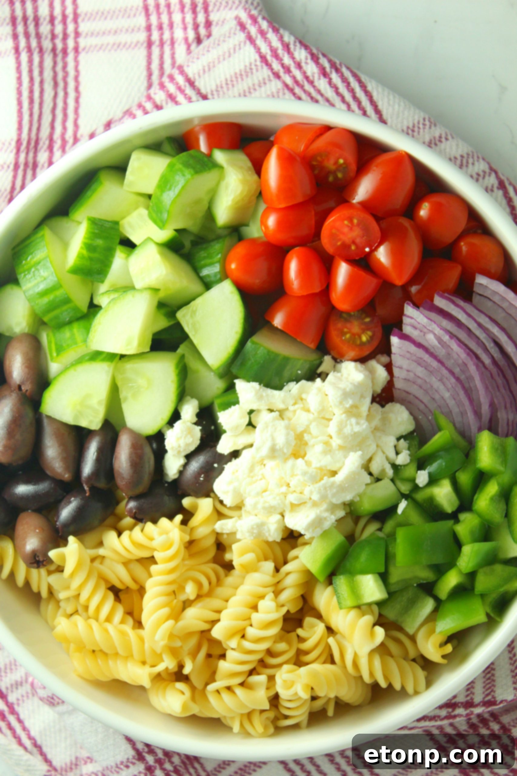 A close-up shot of the Greek Pasta Salad, focusing on the texture of the pasta and vegetables.