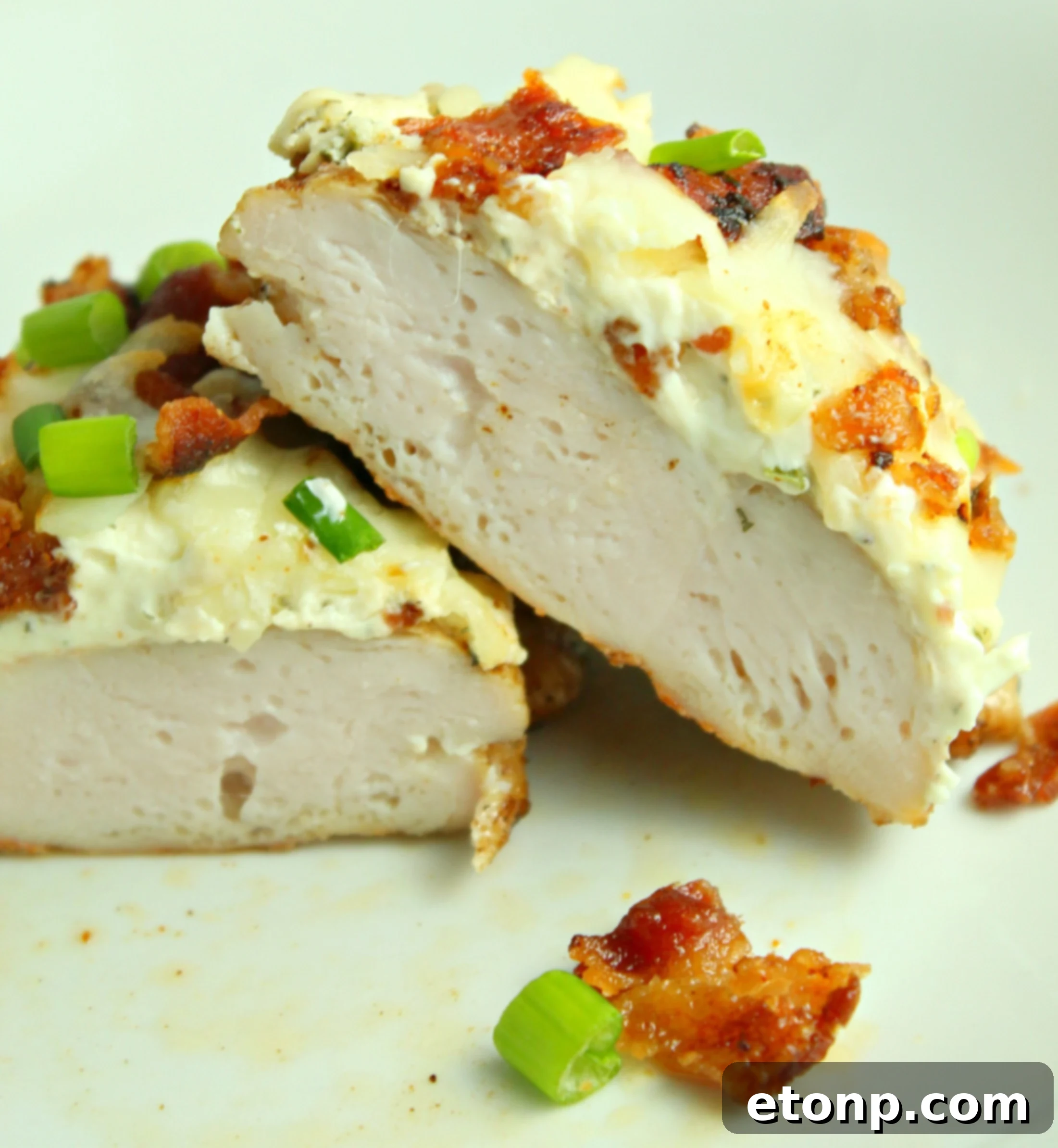 Close-up of baked Smothered Crack Chicken showing golden melted cheese and crispy bacon, ready to be enjoyed