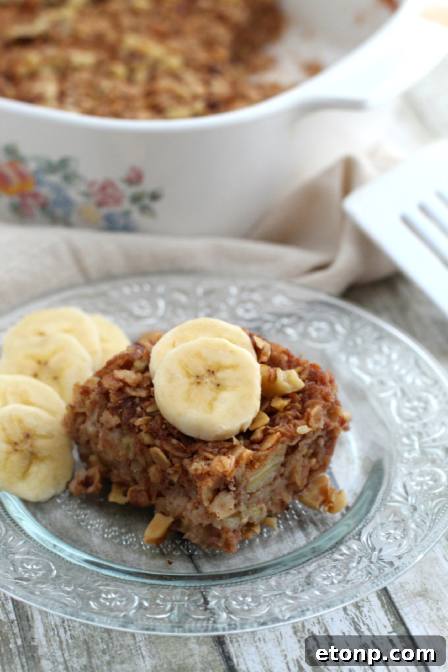 Chewy Banana Bread Oatmeal Bars 6 A hand reaching for a perfectly golden-brown banana bread oatmeal bar, highlighting its grab-and-go appeal.