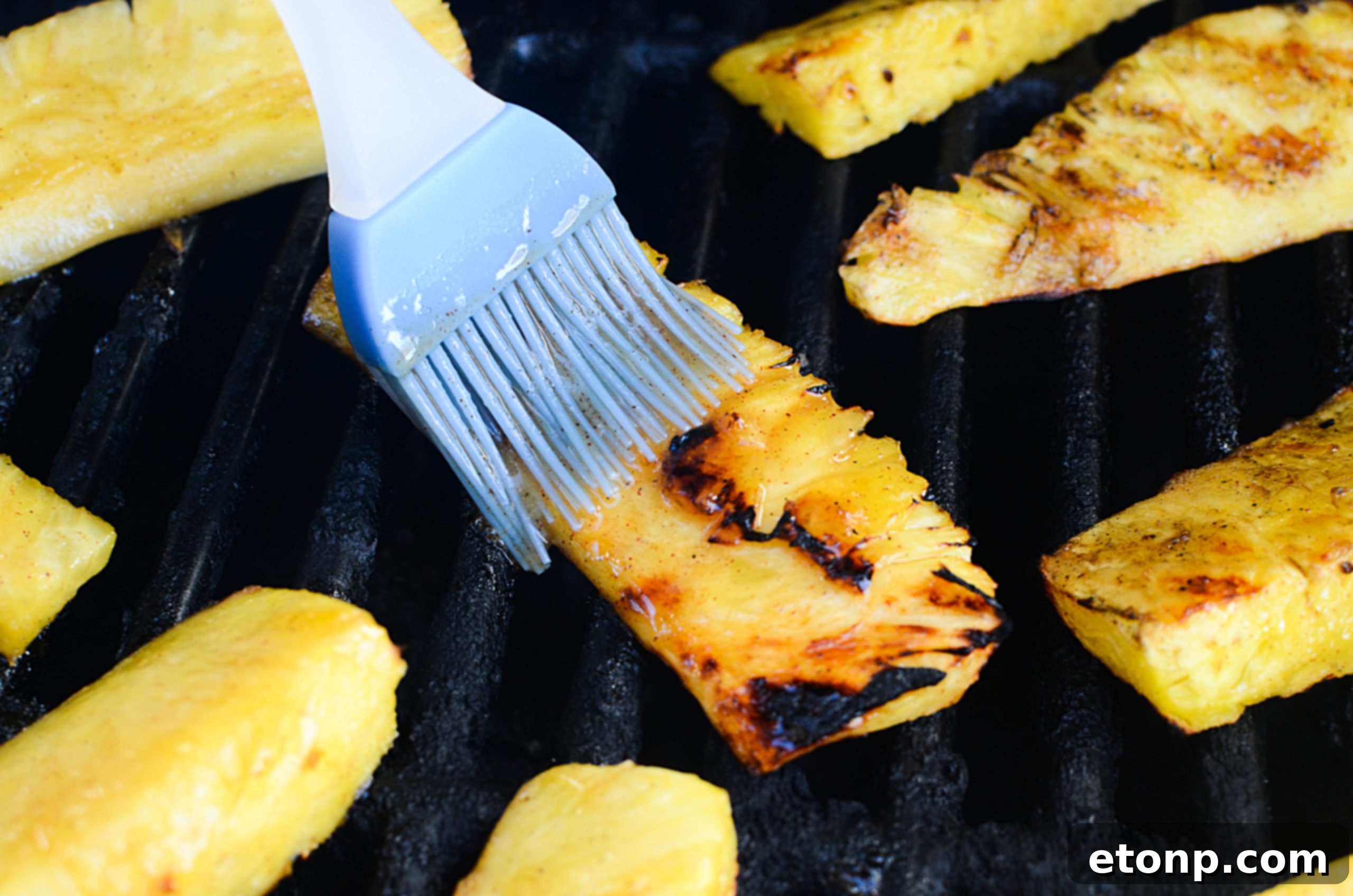 Close-up of grilled pineapple on a cutting board, showcasing its caramelized texture