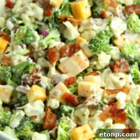 Rich and Flavorful Low Carb Broccoli Cauliflower Salad 10 A vibrant bowl of Loaded Broccoli Cauliflower Salad with a creamy dressing, bacon, and cheese.