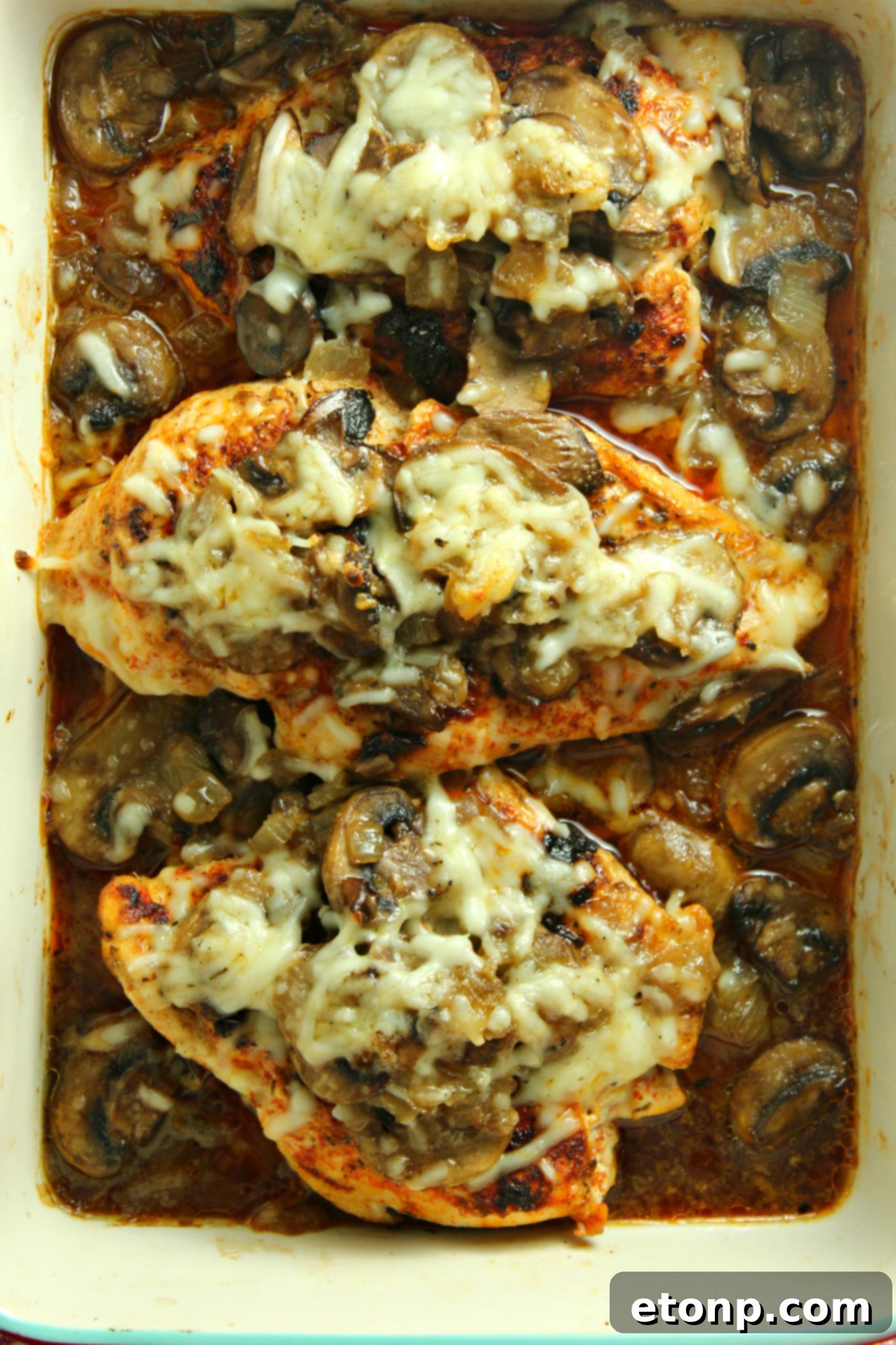 A close-up of a serving of Smothered Cheesy Baked Chicken, ready to be enjoyed, highlighting the rich sauce and perfectly cooked chicken.