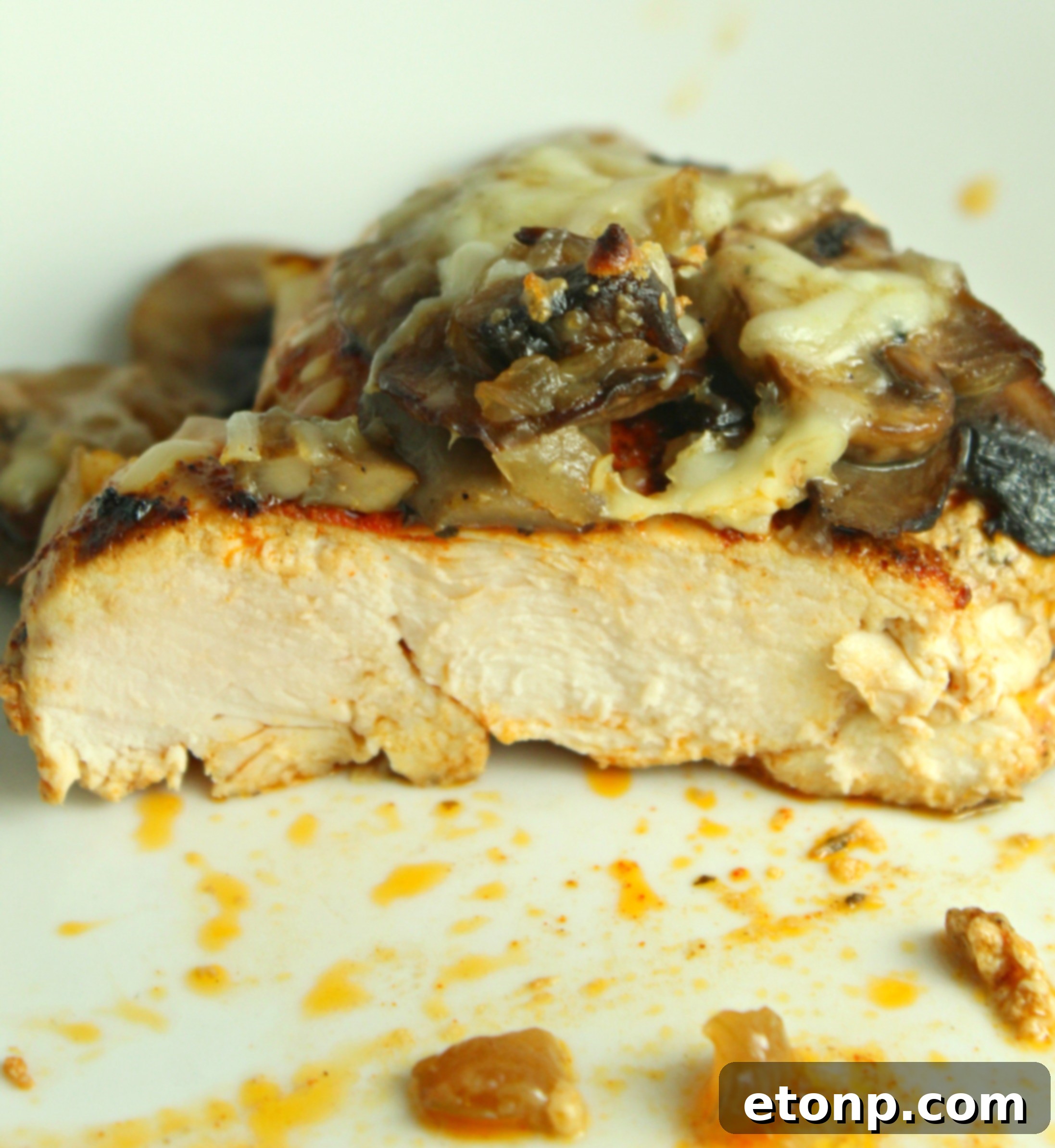 The Smothered Cheesy Baked Chicken with Mushrooms, fresh out of the oven, presenting a golden-brown and bubbling topping.