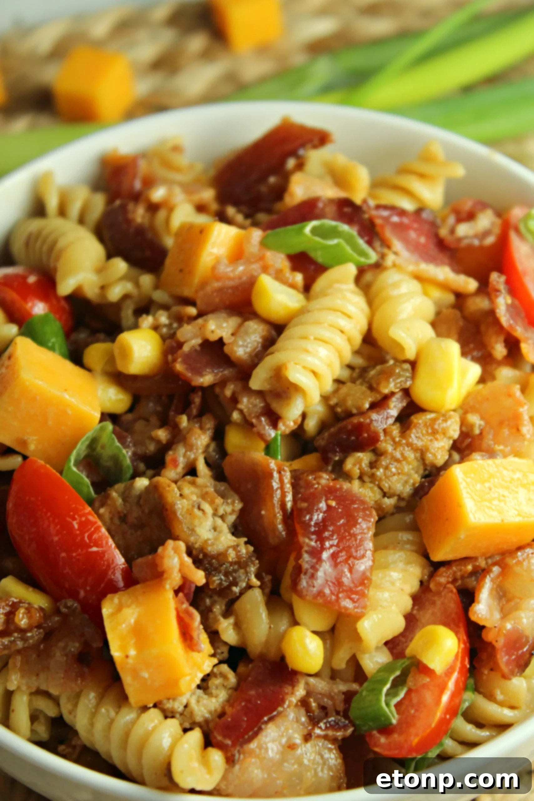 Chuckwagon Pasta Salad 9 Ingredients for Loaded Cowboy Pasta Salad mixing together in a large bowl, showing the preparation process.