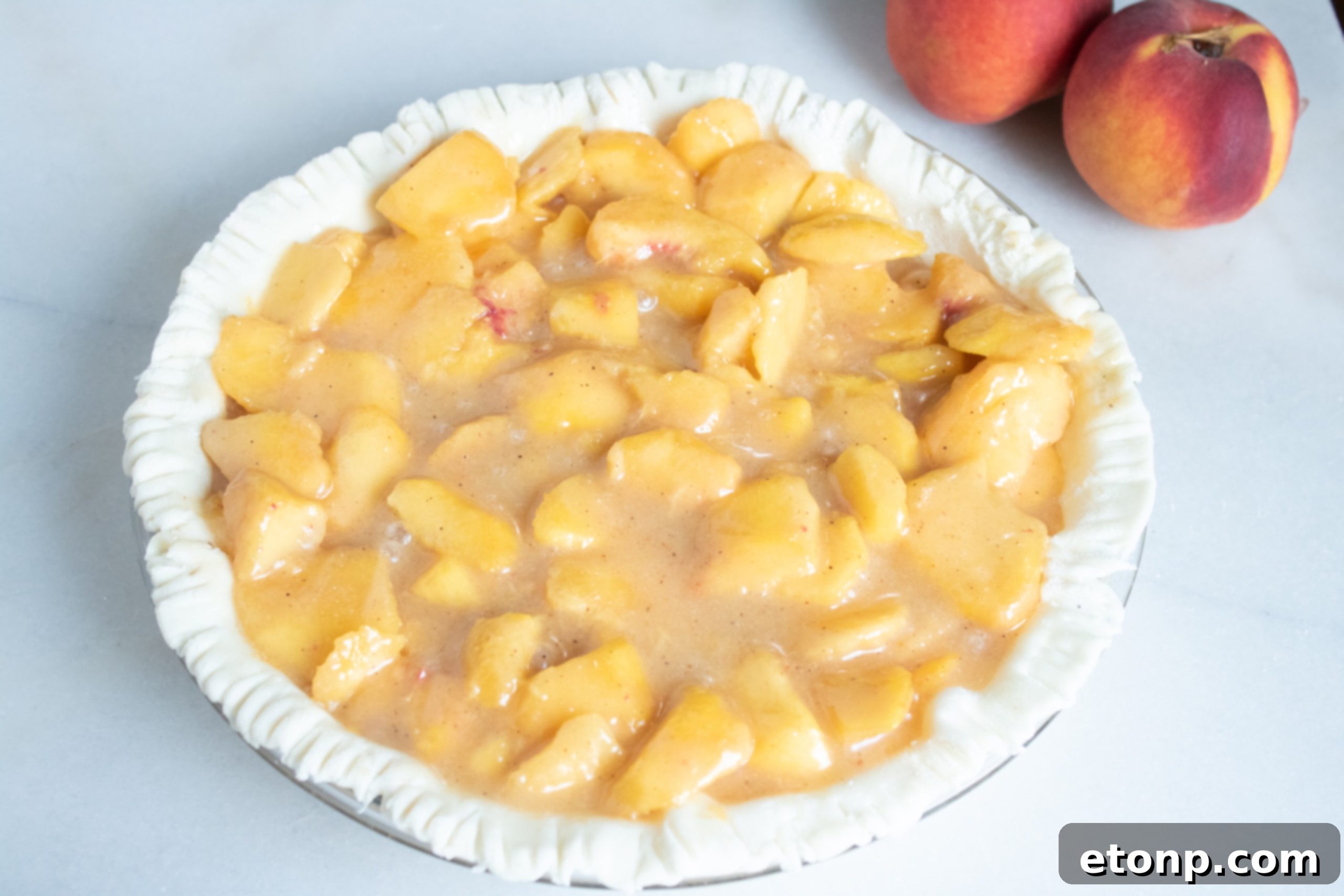 Close-up of a slice of Southern Peach Pie, showing the vibrant peach filling