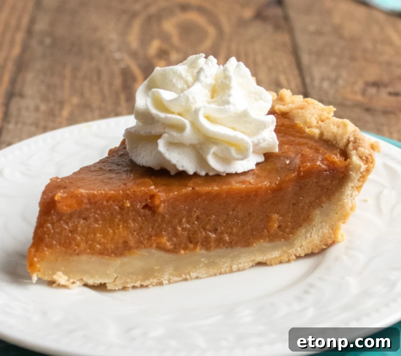 An overhead view of a whole sweet potato pie, adorned with a delicate crust design, ready for presentation.