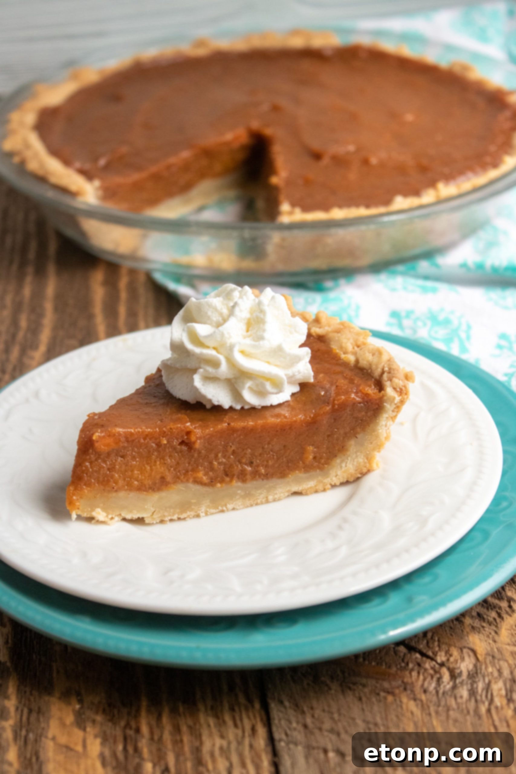 A close-up of a partially eaten sweet potato pie, revealing its creamy, vibrant orange filling.