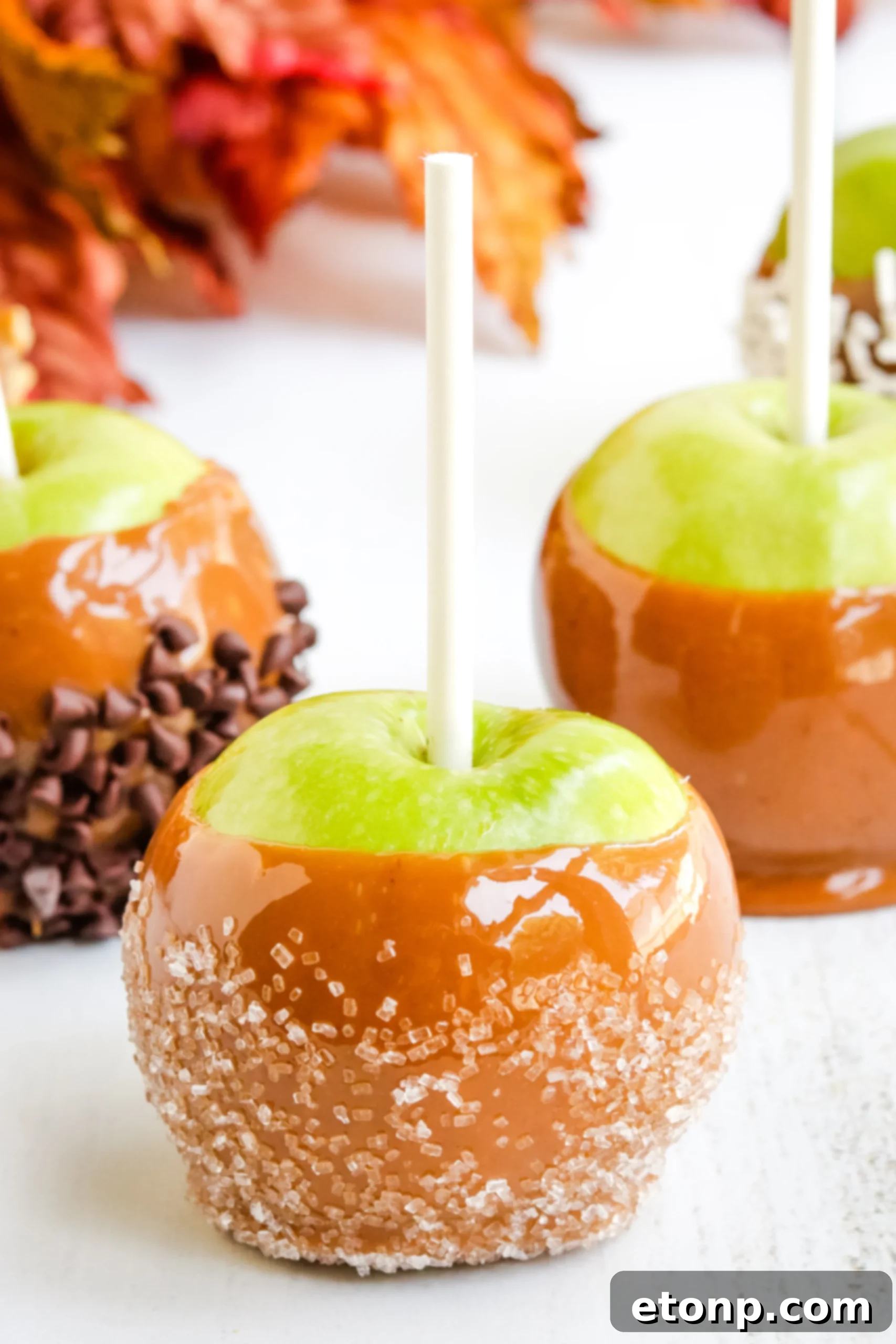 Close-up of a homemade caramel apple with a glossy, golden caramel coating
