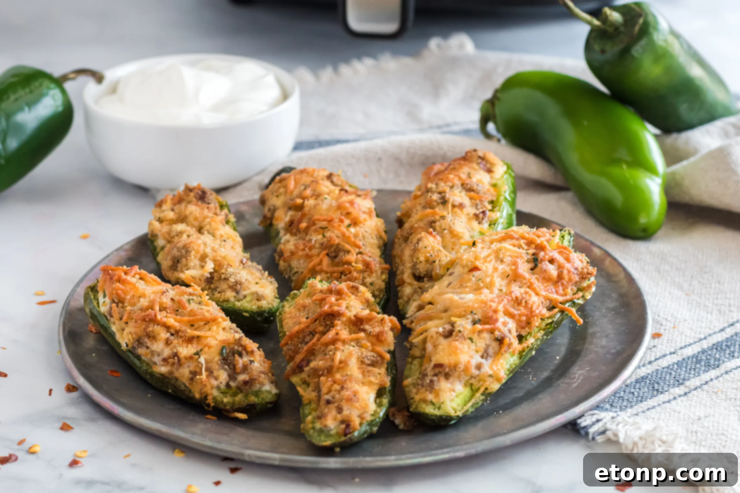 Finished Air Fryer Jalapeno Poppers arranged on a serving plate, garnished with fresh parsley.