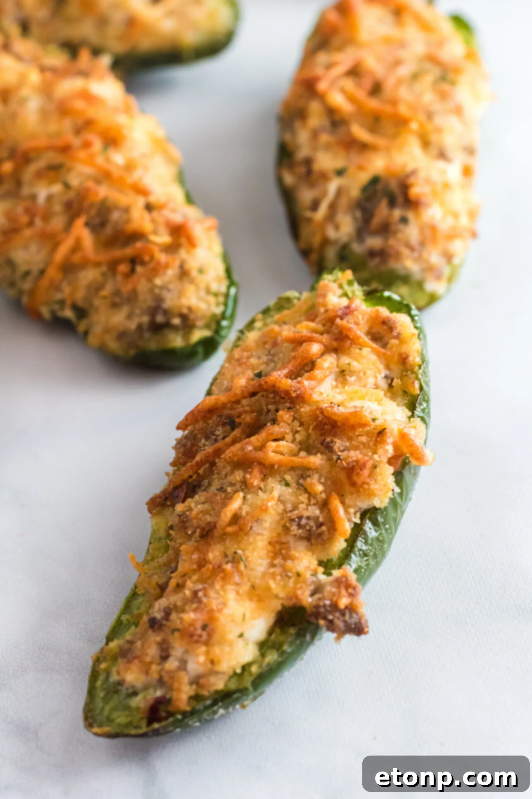 A close-up shot of the air fryer basket with freshly cooked jalapeno poppers, showing their golden crust.