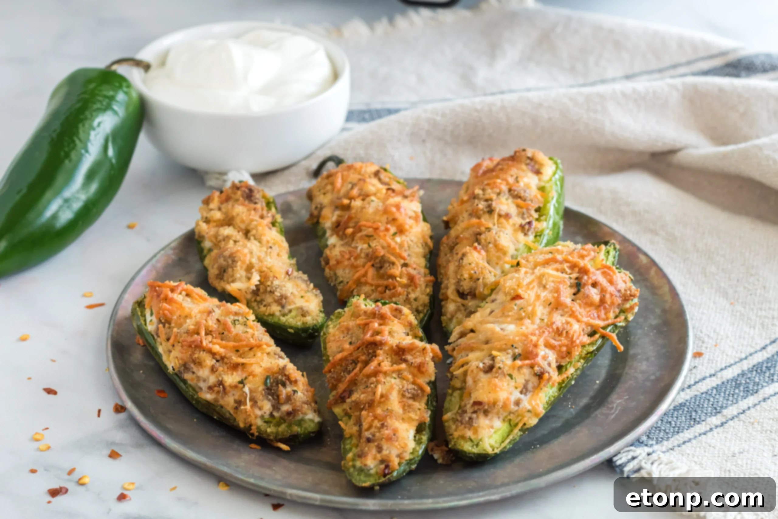 Air Fryer Jalapeno Poppers on a wooden board, garnished with fresh herbs and ready for enjoyment.