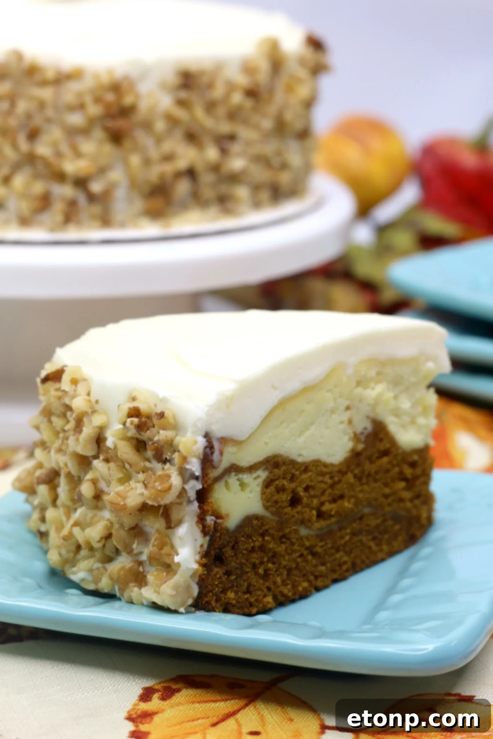 Top-down view of a beautifully baked Pumpkin Cake Cheesecake, showcasing its creamy frosting and a hint of the layered texture
