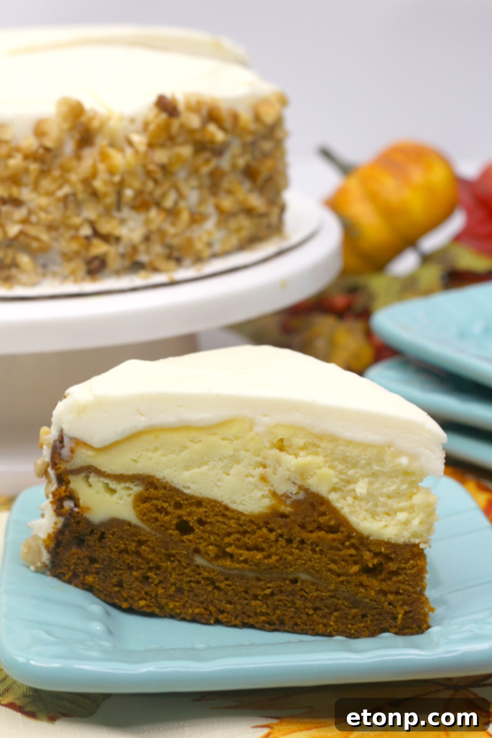 Another enticing angle of the Pumpkin Cake Cheesecake, showing its rich, golden-brown top and thick layer of cream cheese frosting