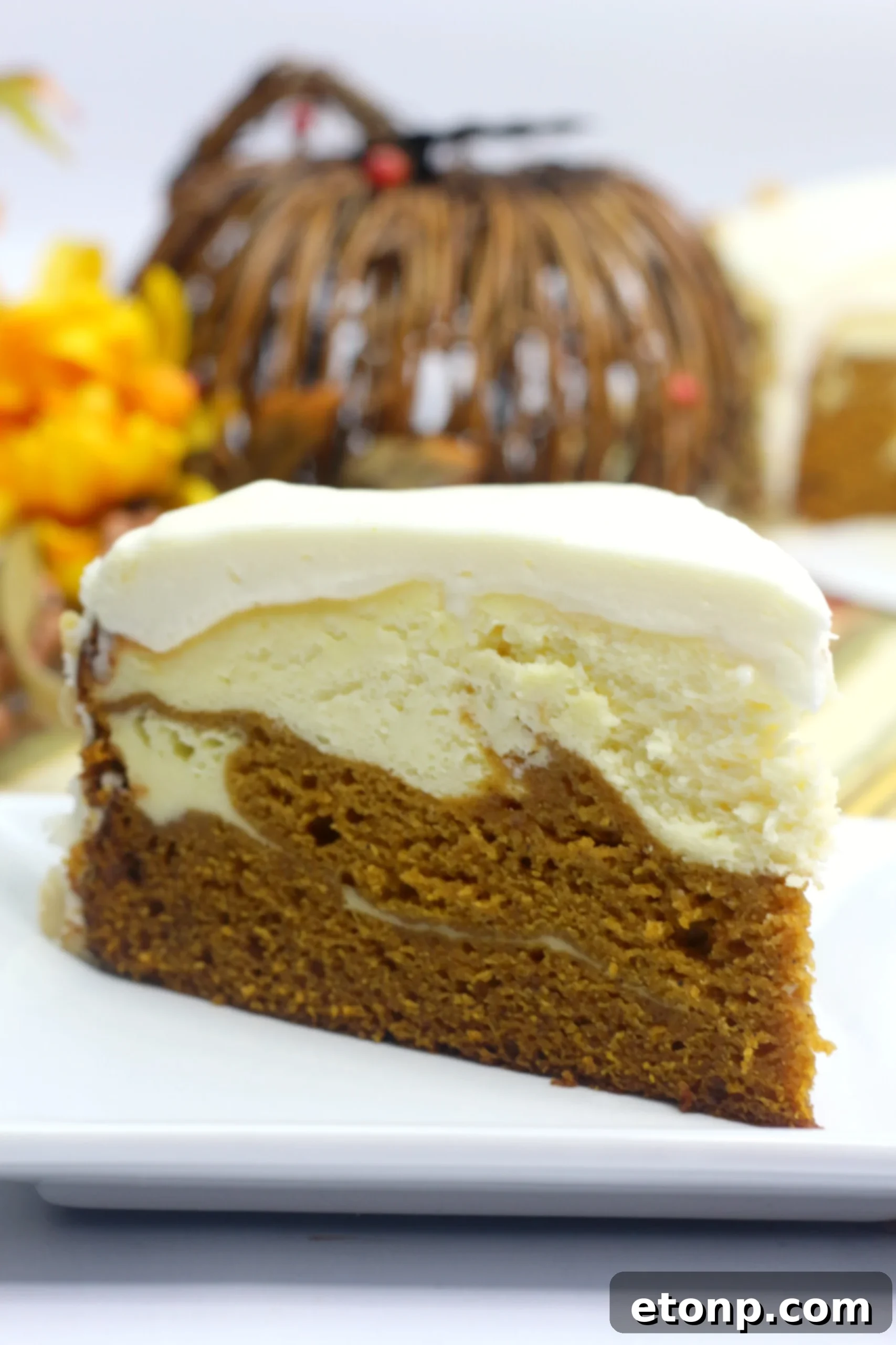 A full, frosted Pumpkin Cake Cheesecake, garnished with chopped walnuts on the sides, showcasing its readiness to be sliced and enjoyed