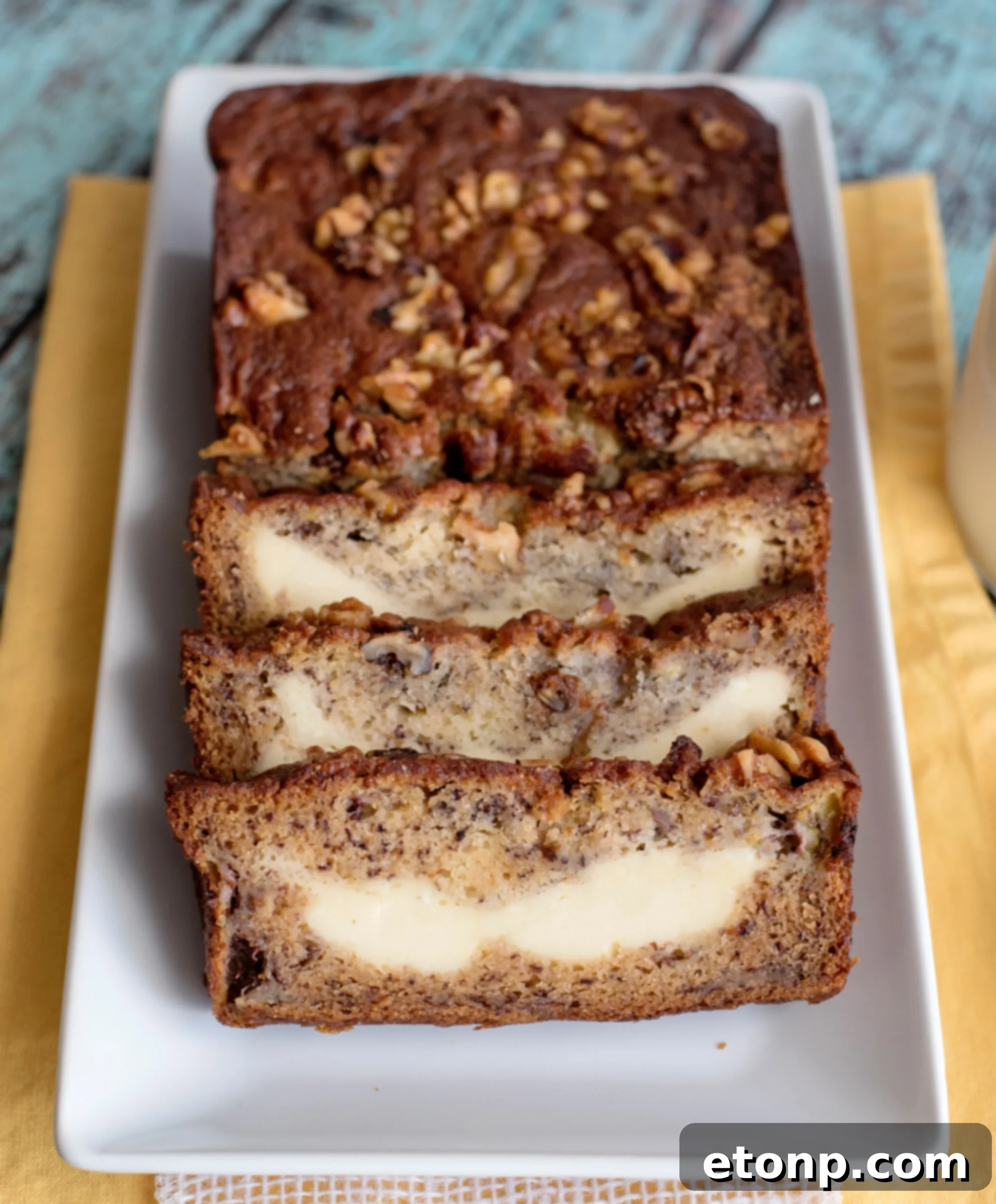 A slice of Cream Cheese Banana Bread showing the creamy swirl.