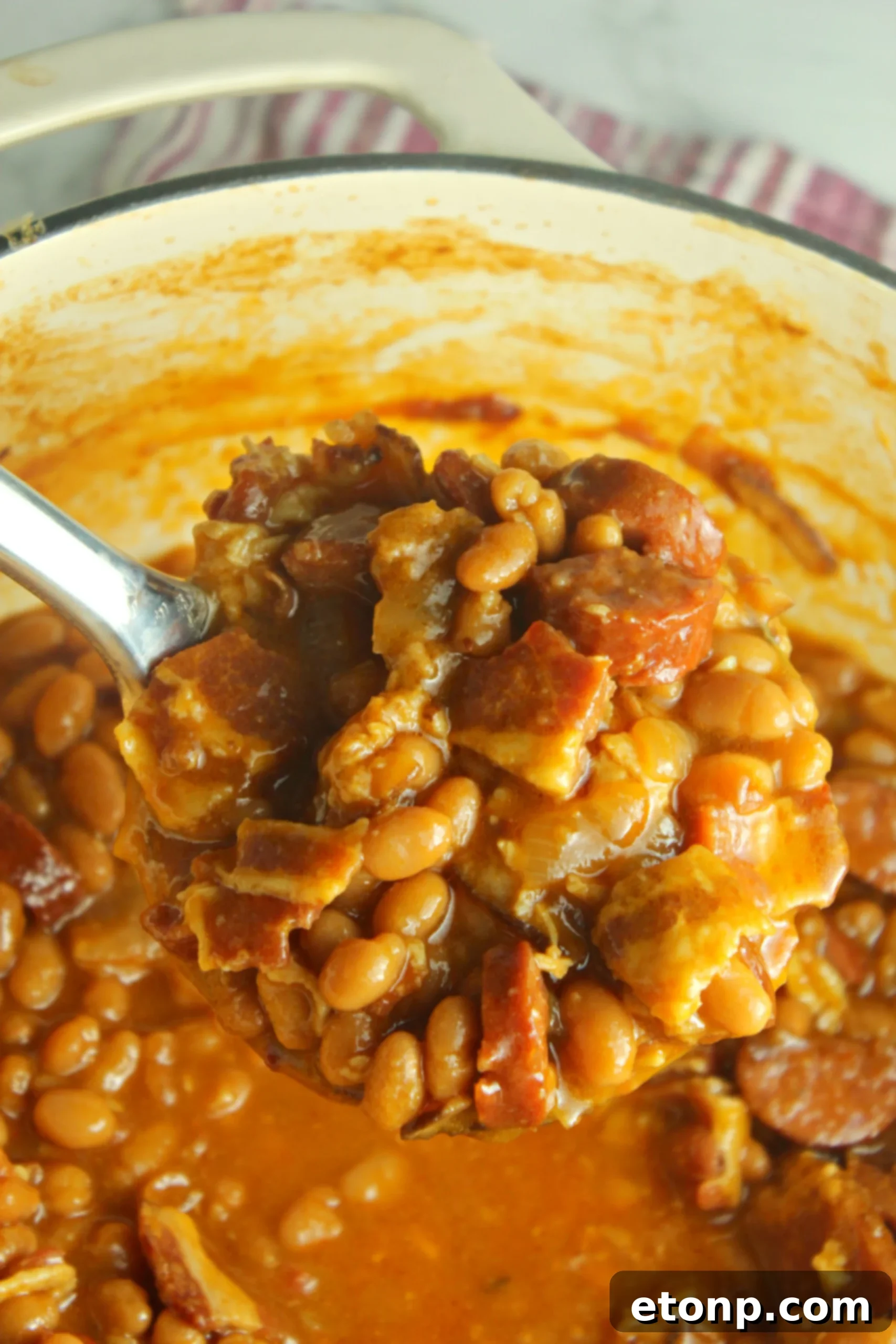 A final full shot of the baked beans with smoked sausage in the dutch oven, garnished and ready for serving.