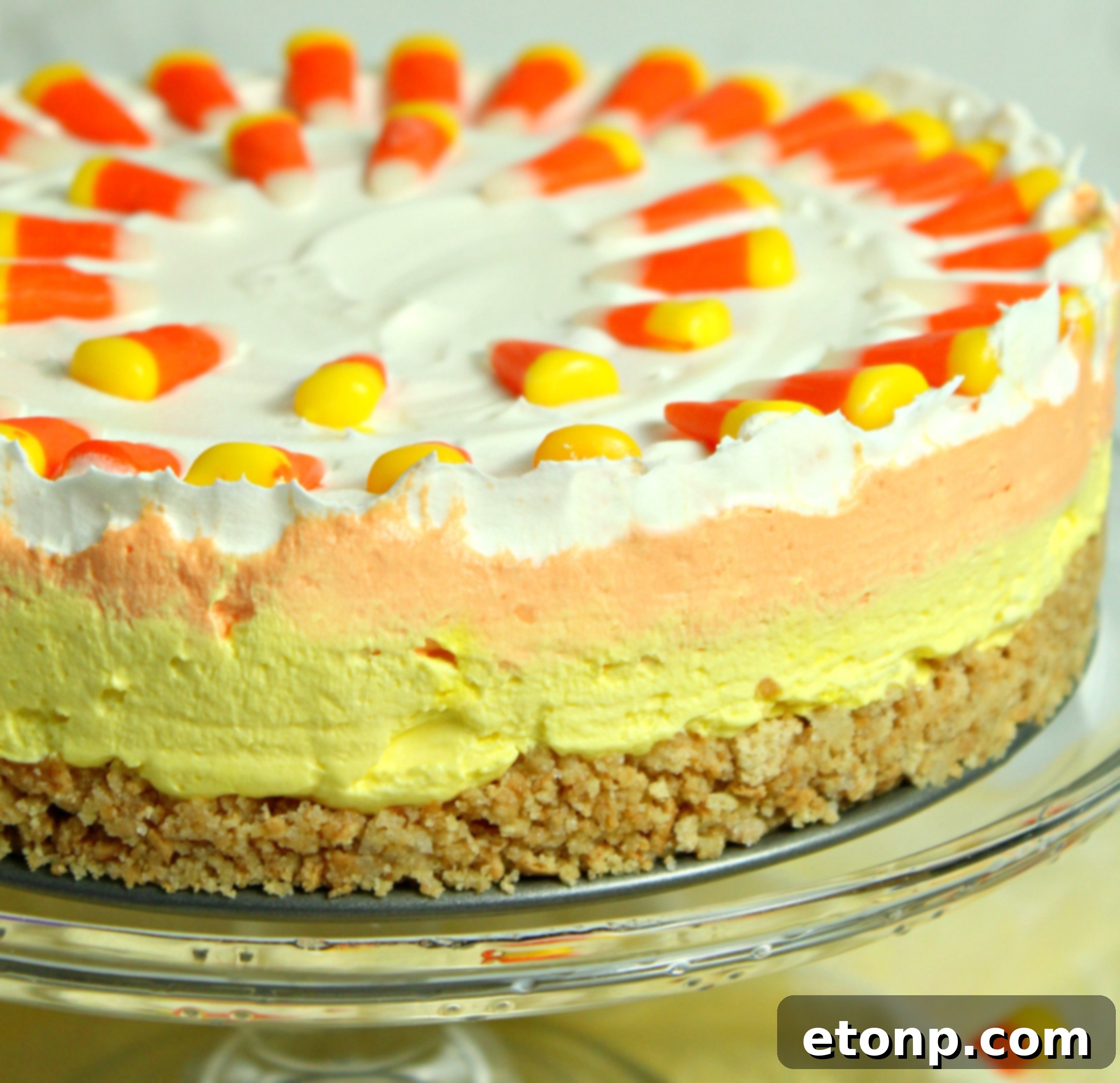 An overhead shot of the No-Bake Candy Corn Cheesecake, highlighting its perfectly segmented layers and a generous topping of real candy corn.
