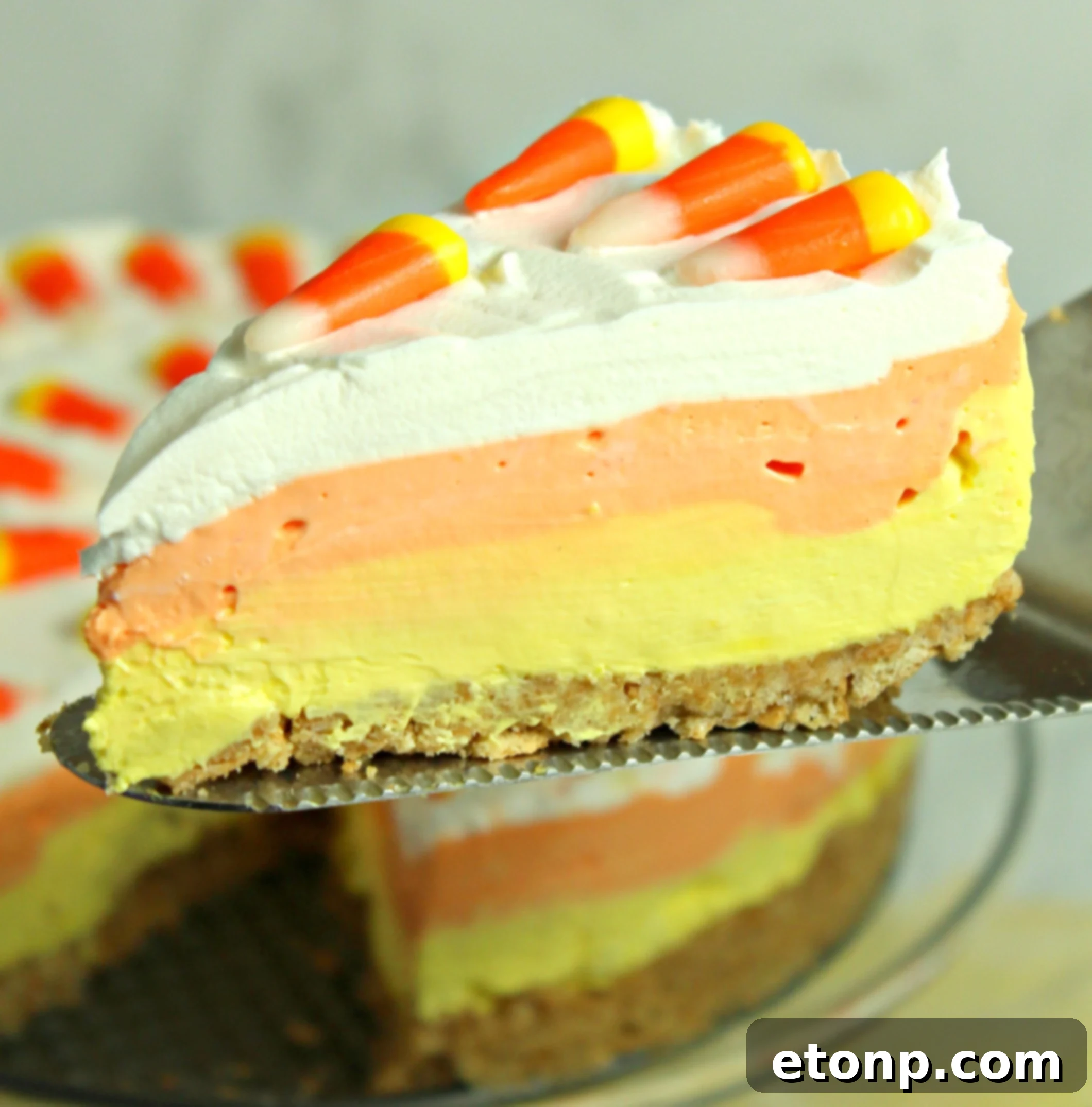 A side view of the No-Bake Candy Corn Cheesecake, showing the smooth, creamy texture of each colorful layer.