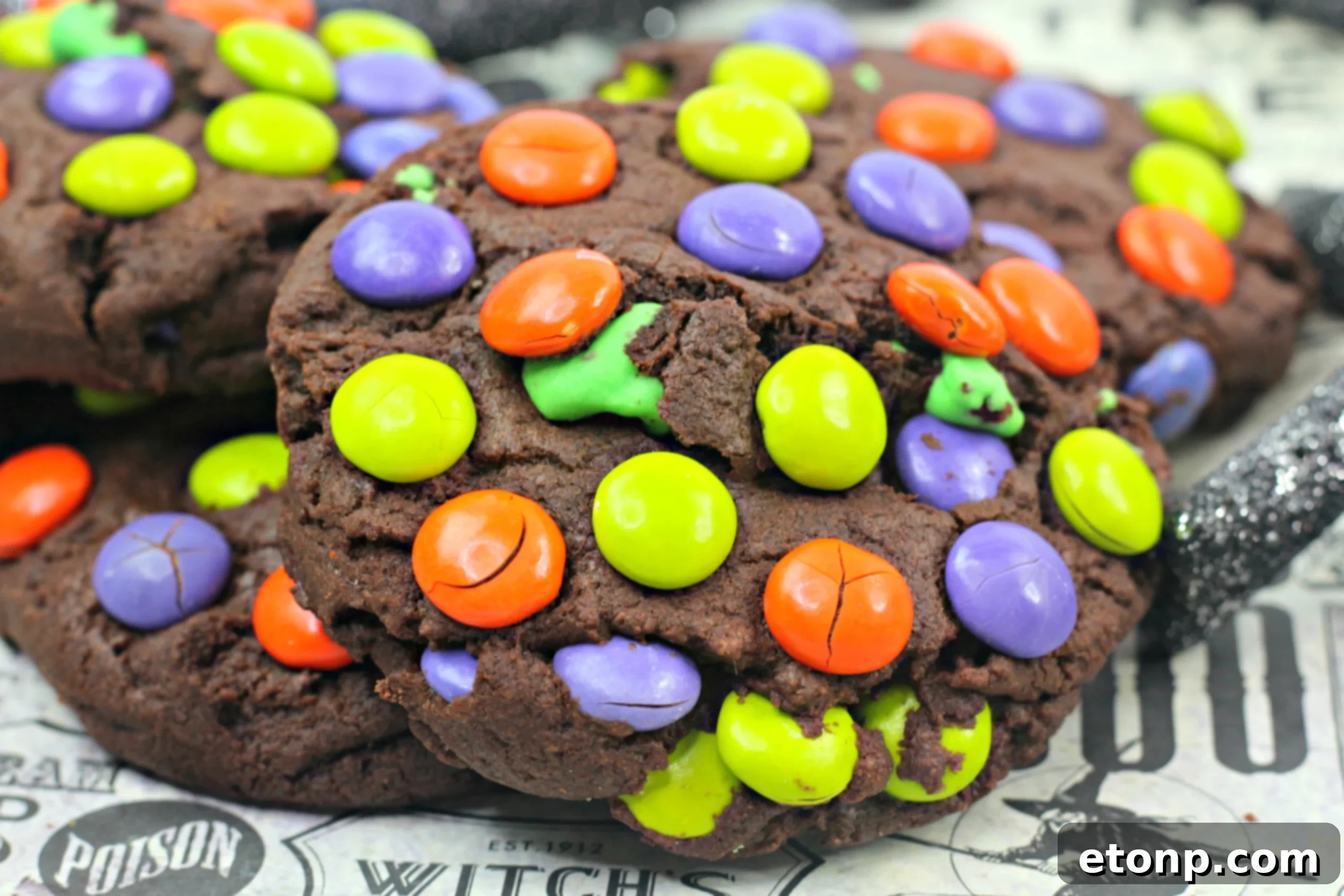 Two Monster Mash Chocolate Cookies stacked on a plate, showcasing their thick, chewy texture and colorful M&Ms.