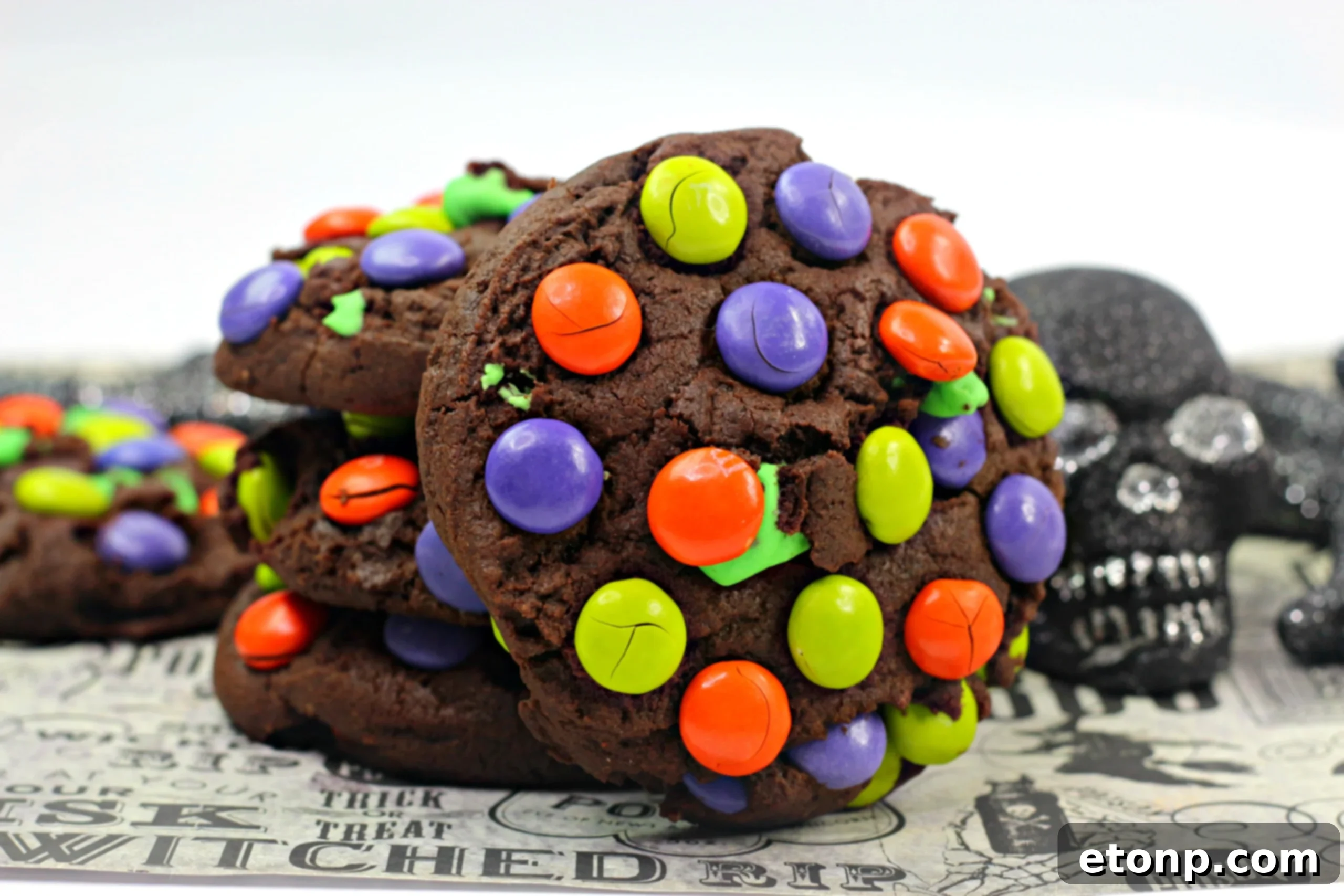 A close-up of a Monster Mash Chocolate Cookie, showing the cracked top and visible M&Ms, ready to be enjoyed.