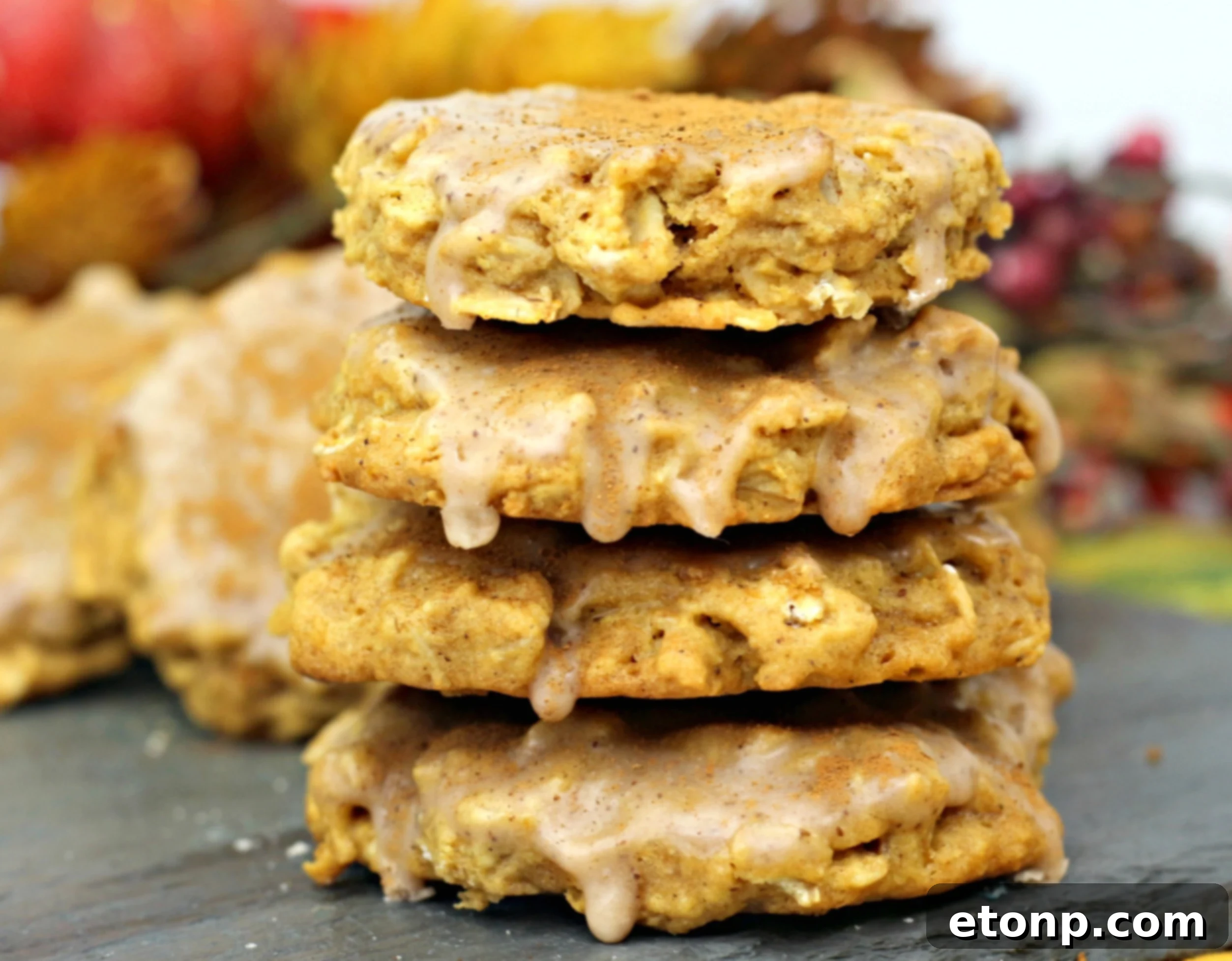 A top-down view of several Iced Pumpkin Oatmeal Cookies on a white plate, ready to be served.