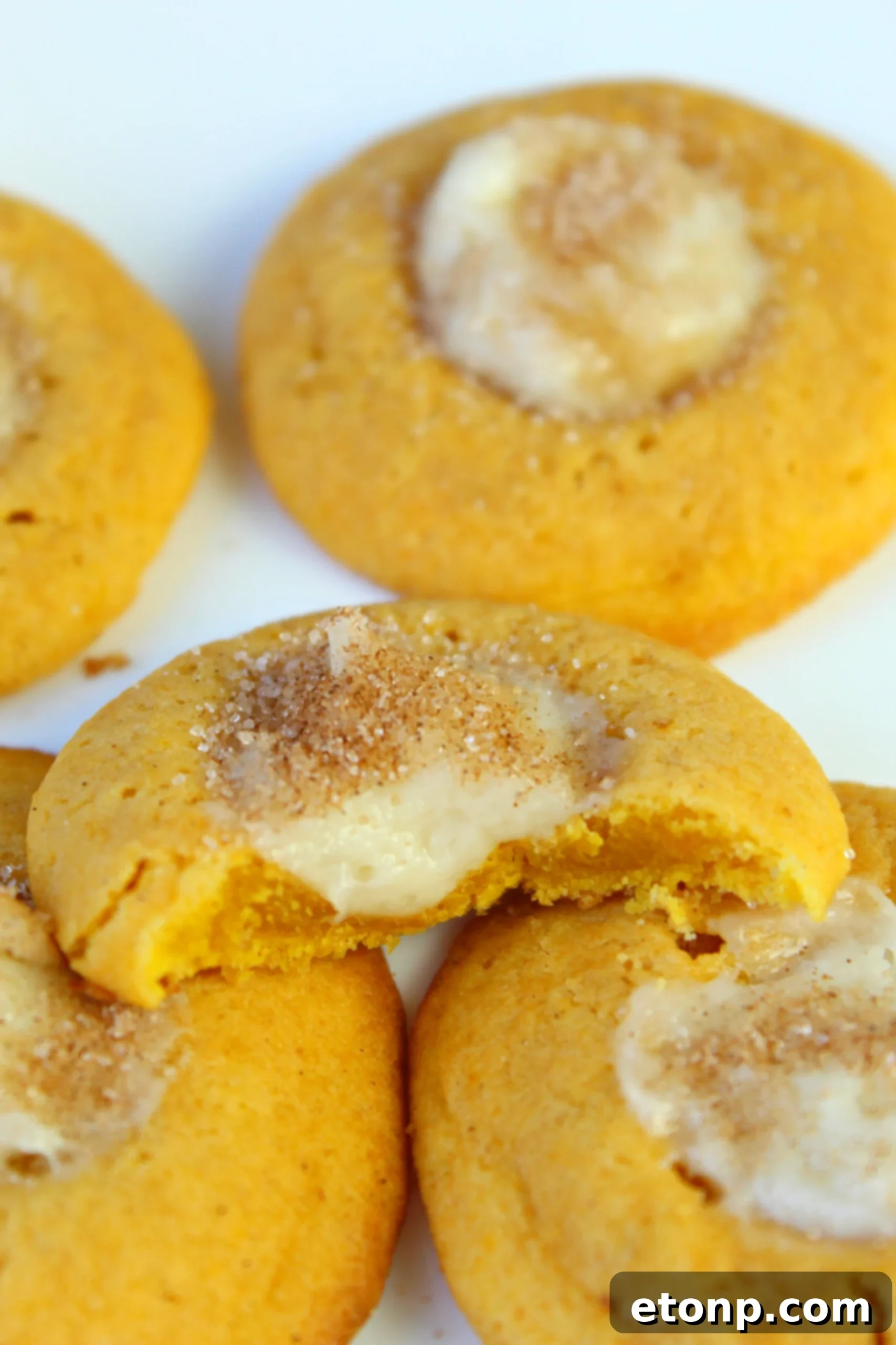 Close-up of baked pumpkin cheesecake thumbprint cookies, showing their perfect shape and creamy filling