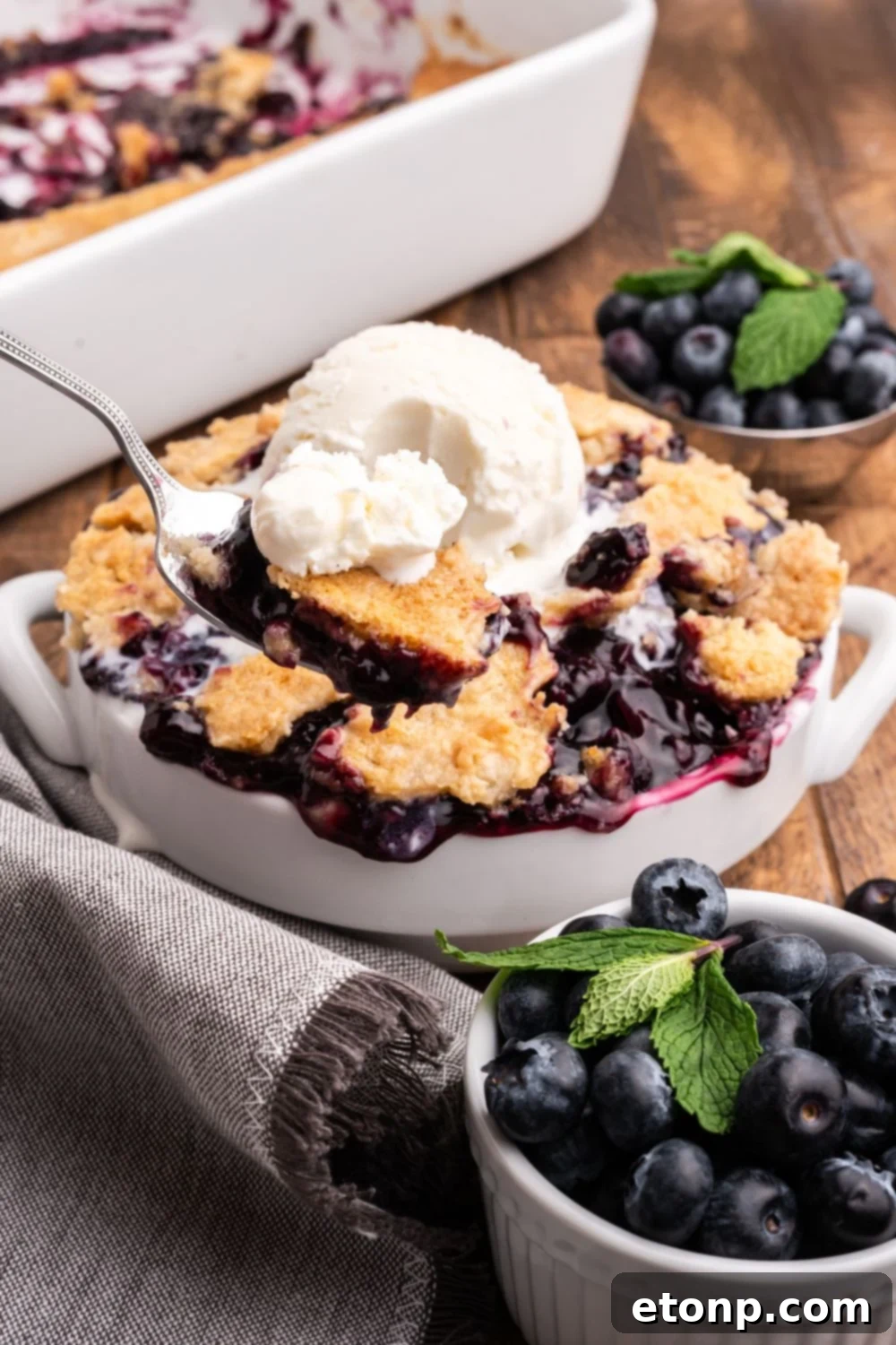 spoon scooping in a bowl with dump cake and ice cream