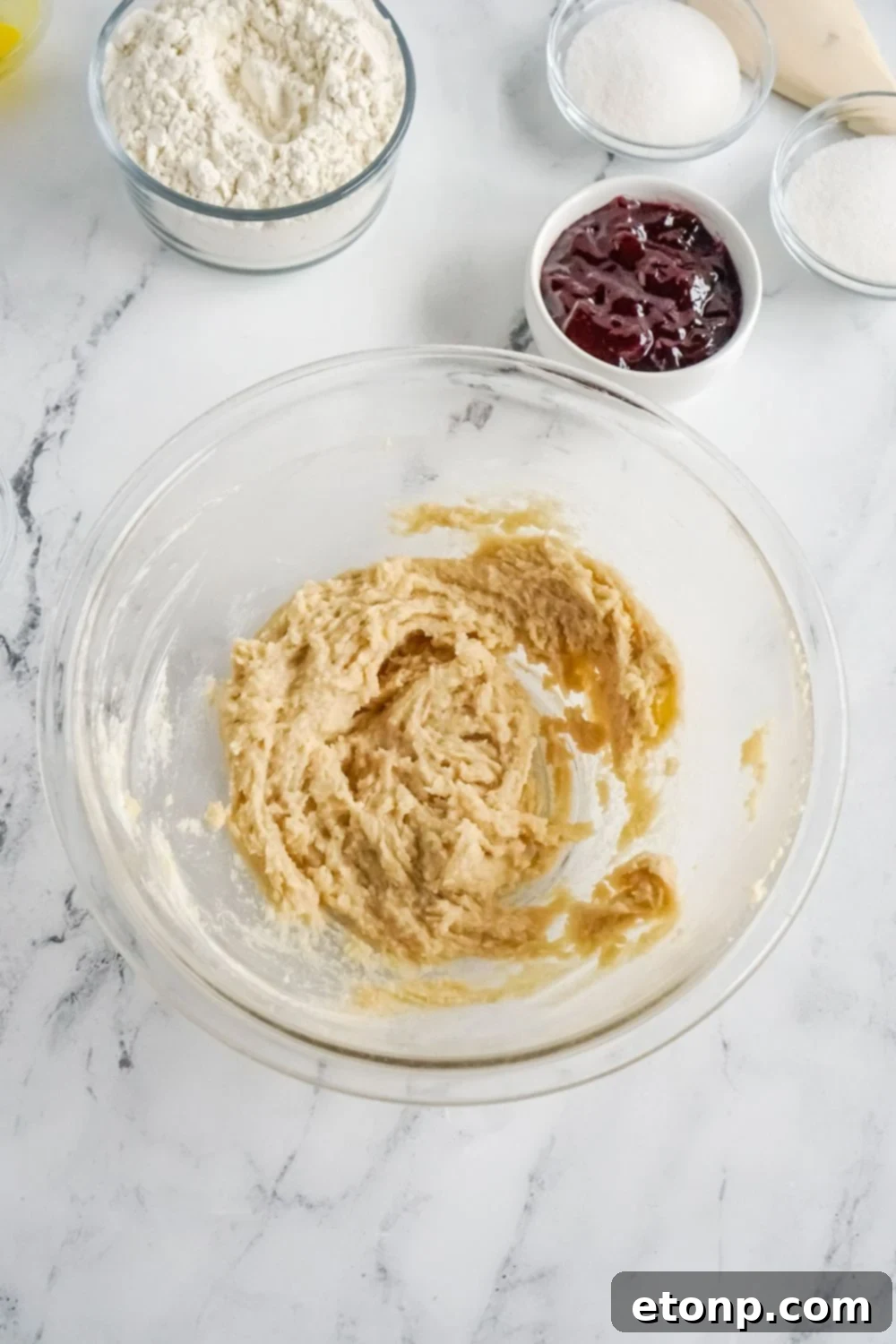 Raspberry Thumbprint Cookie dough in a clear glass bowl, ready for shaping.