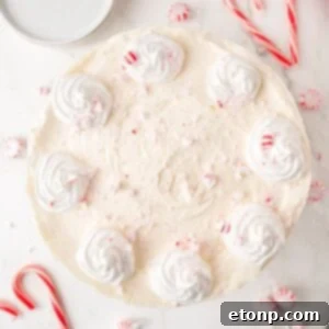 No Bake Peppermint Cheesecake on white table with candy canes around it on table