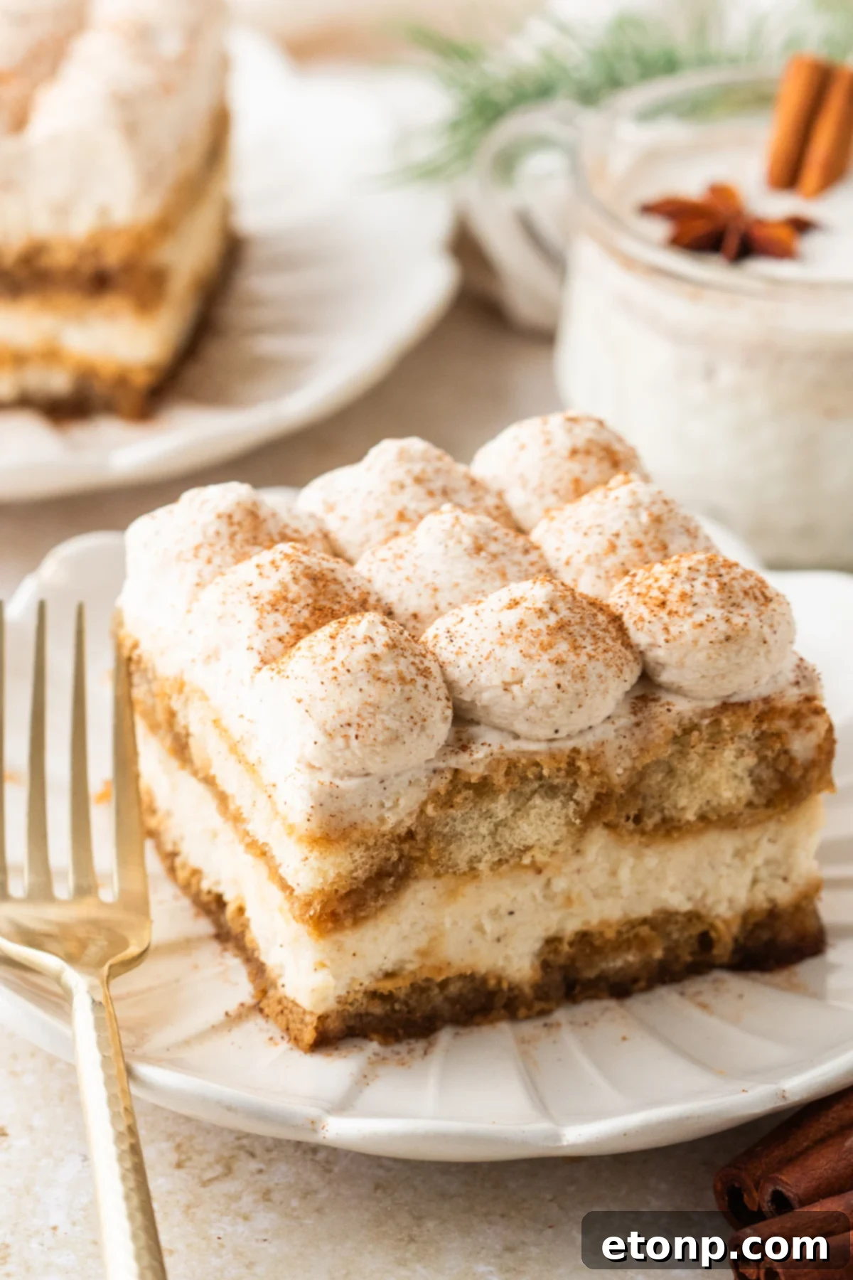 Eggnog Tiramisu: A Festive Holiday Treat 2 No Bake Eggnog Tiramisu sliced on white serving plates with a glass of eggnog behind the plate