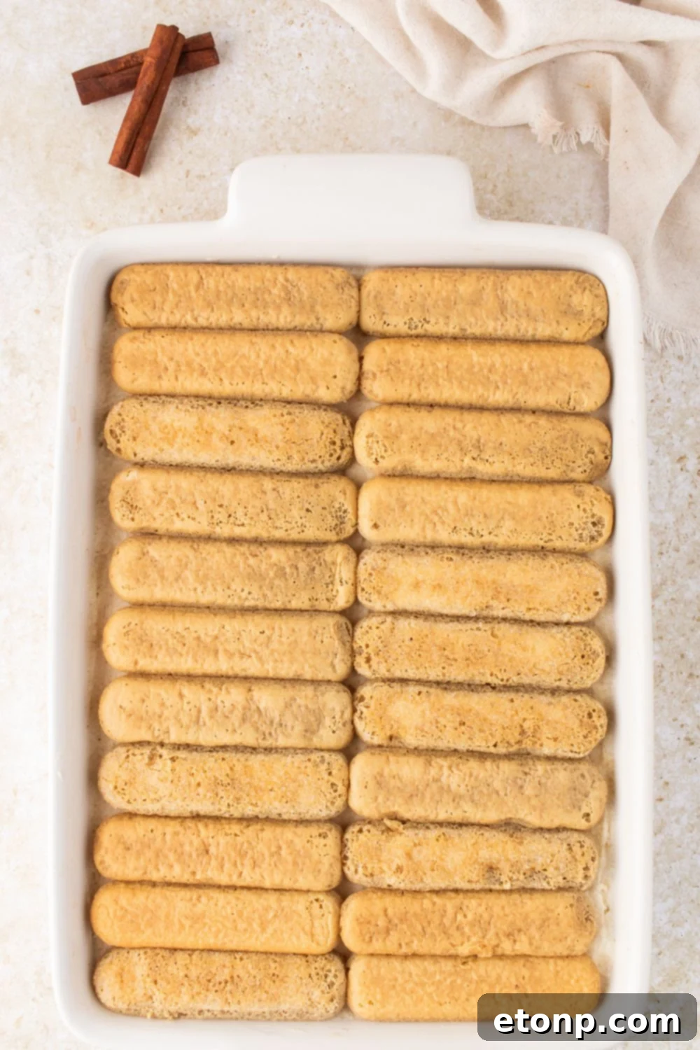 Eggnog Tiramisu: A Festive Holiday Treat 12 Dipped ladyfingers in a casserole dish on the table