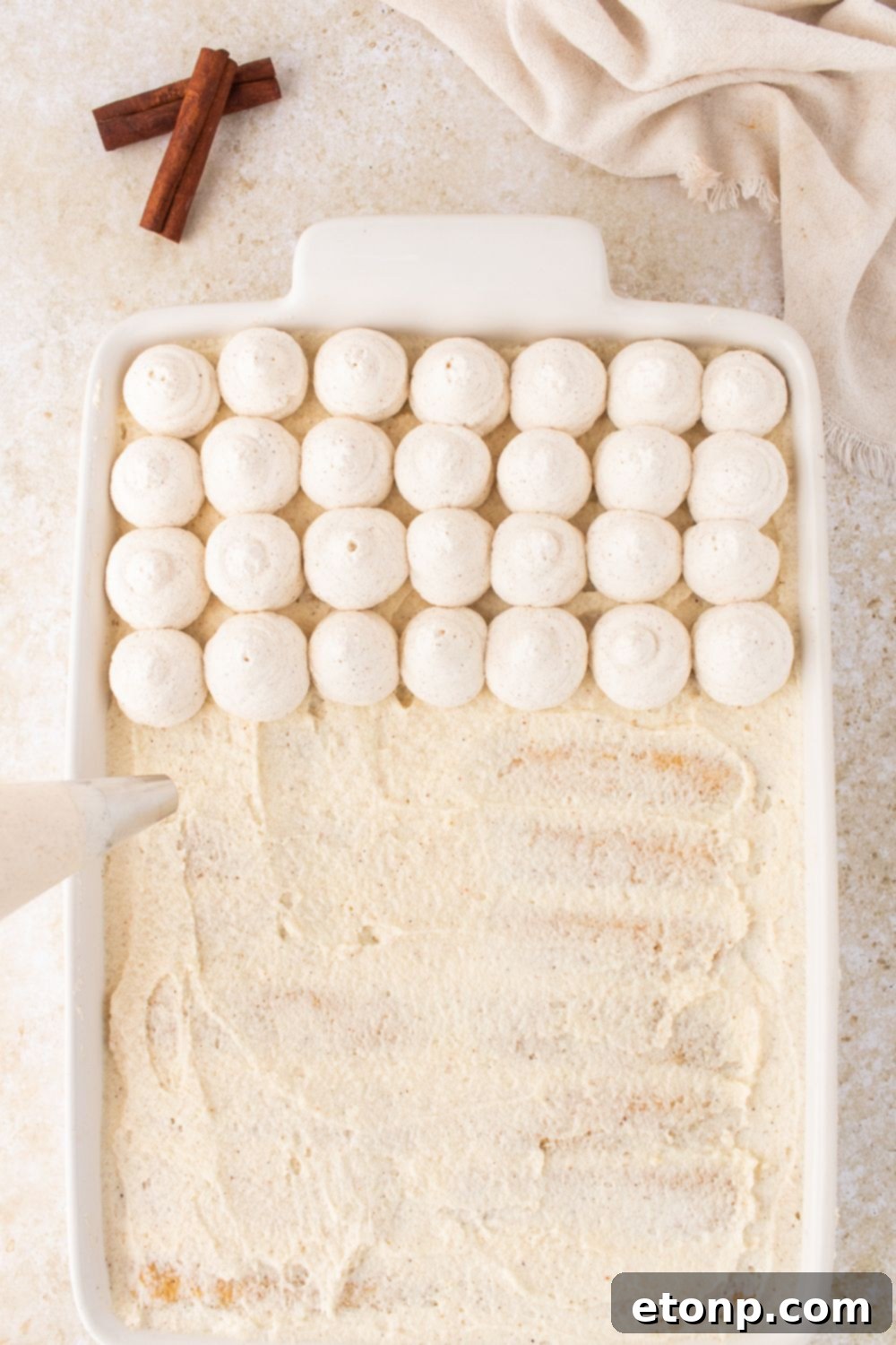 Eggnog Tiramisu: A Festive Holiday Treat 14 Piping topping on top of the Eggnog Tiramisu