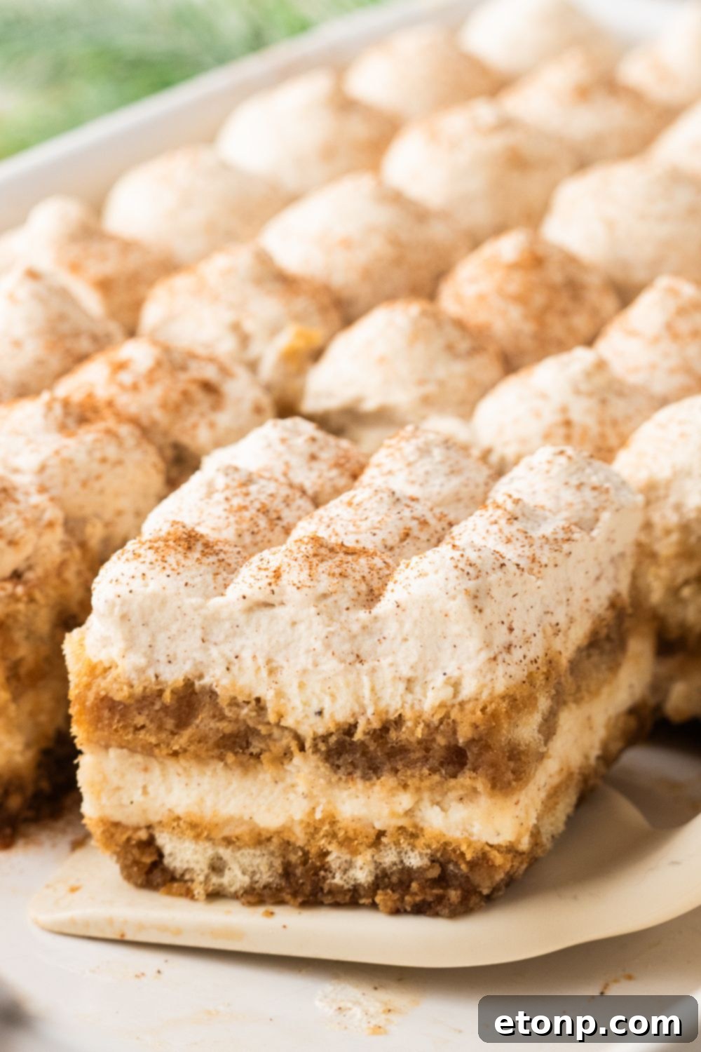 Eggnog Tiramisu: A Festive Holiday Treat 16 A slice of eggnog tiramisu sliced and lifting out of the casserole pan