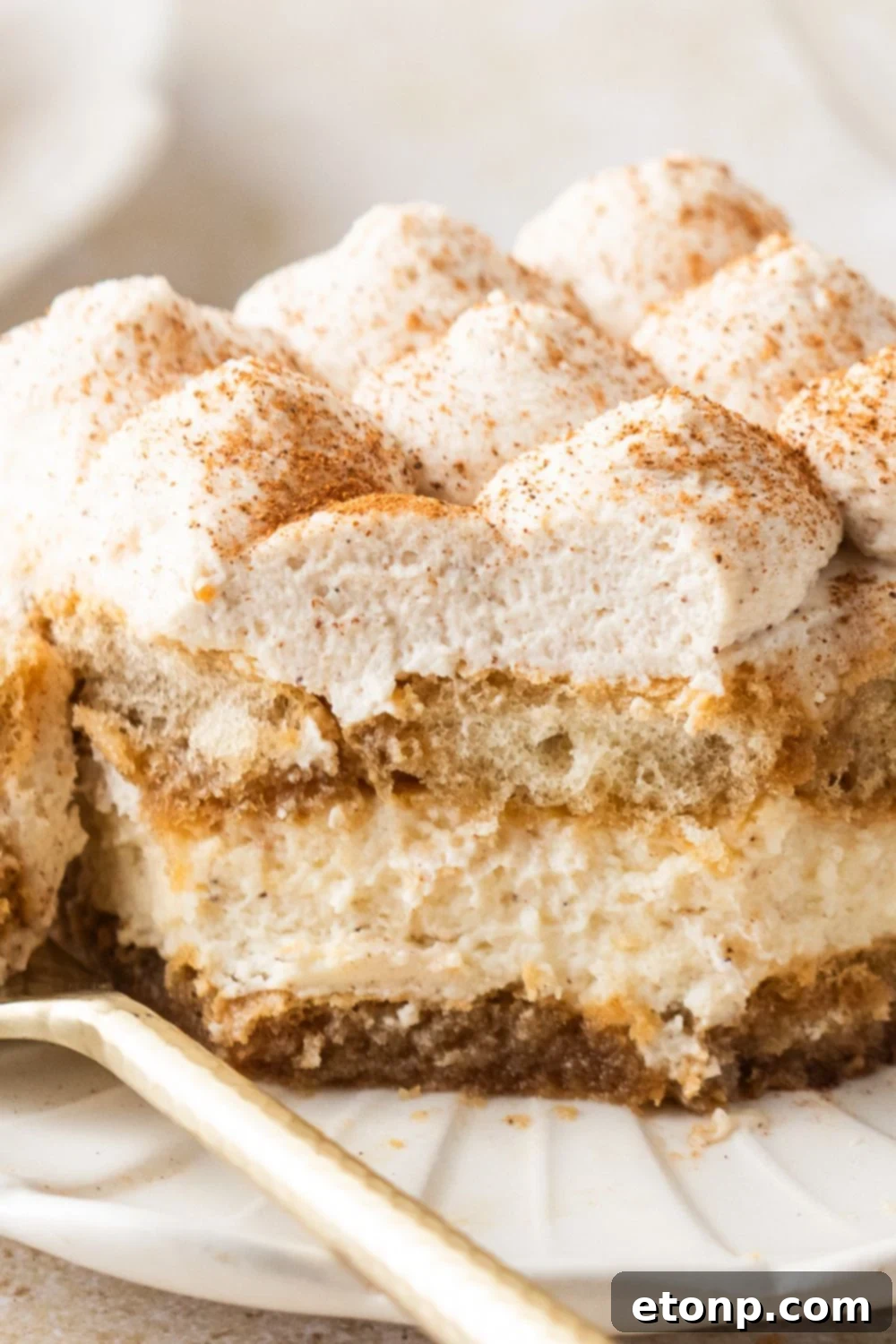 Eggnog Tiramisu: A Festive Holiday Treat 17 Eggnog Tiramisu on plate with a couple bites taken out of it showing the layers of the dessert