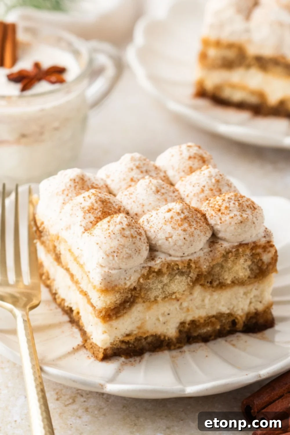Eggnog Tiramisu: A Festive Holiday Treat 18 Eggnog Tiramisu sliced on white plates with a glass of eggnog behind the plate