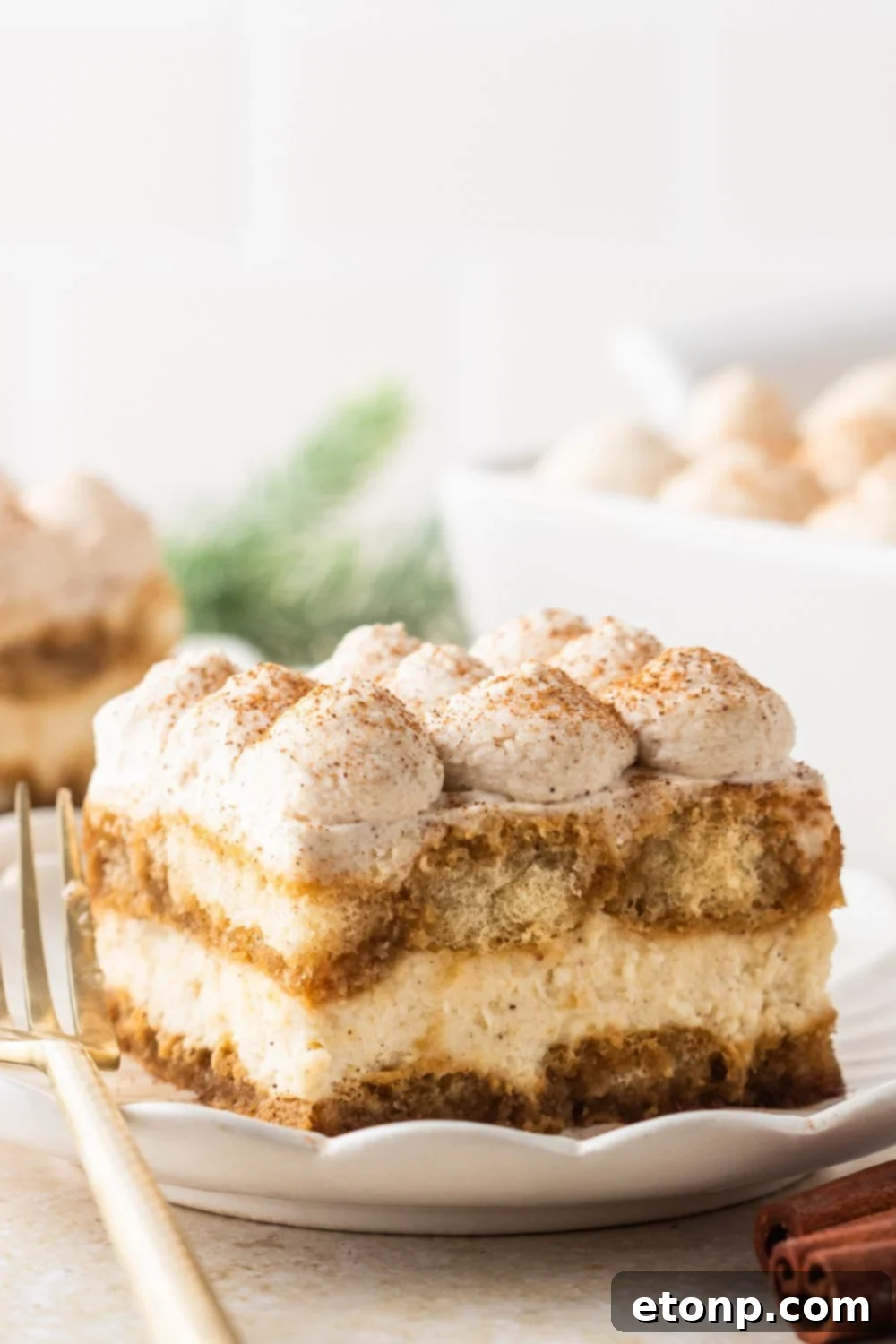Eggnog Tiramisu: A Festive Holiday Treat 19 Slice of eggnog dessert sliced and placed on plate with more plates in the background