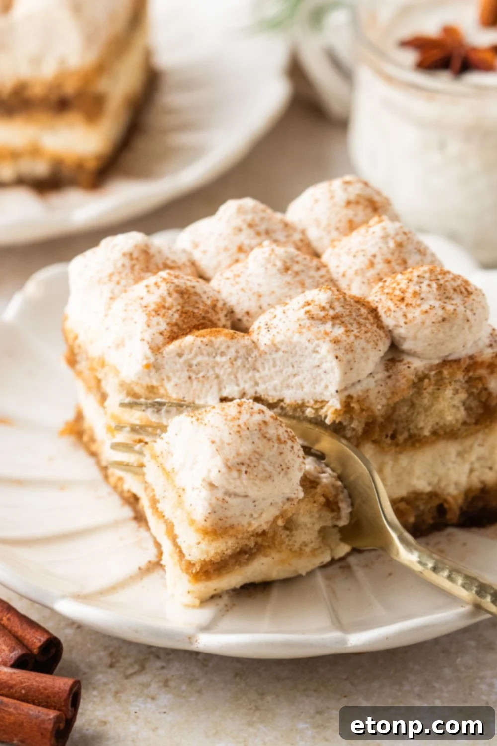 Eggnog Tiramisu: A Festive Holiday Treat 5 Eggnog Tiramisu on a white plate with a fork slicing into a piece of it