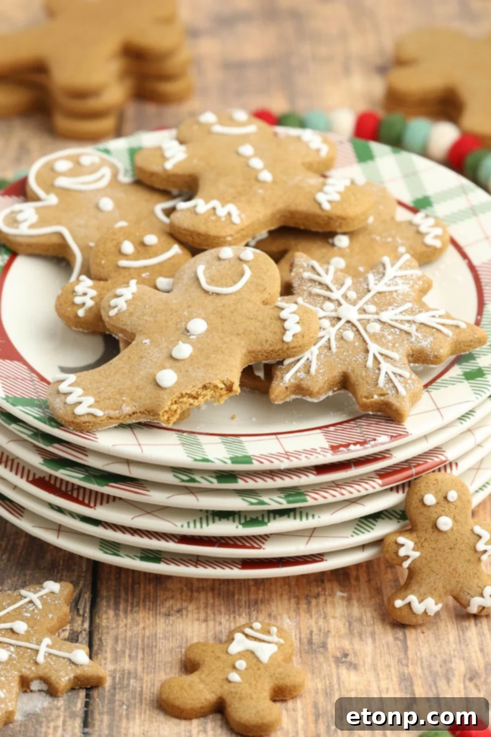 Stack of plates with gingerbread cookies, one with a bite taken out of it.