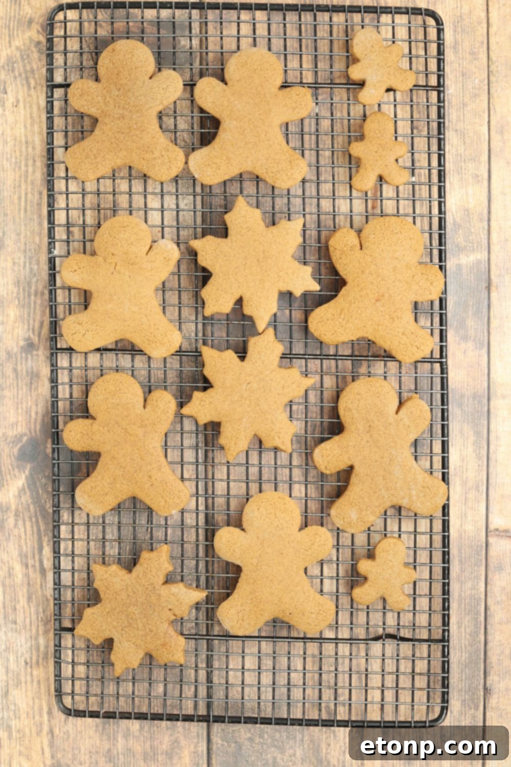 Baked Christmas gingerbread cookies on a cooling rack on a table.