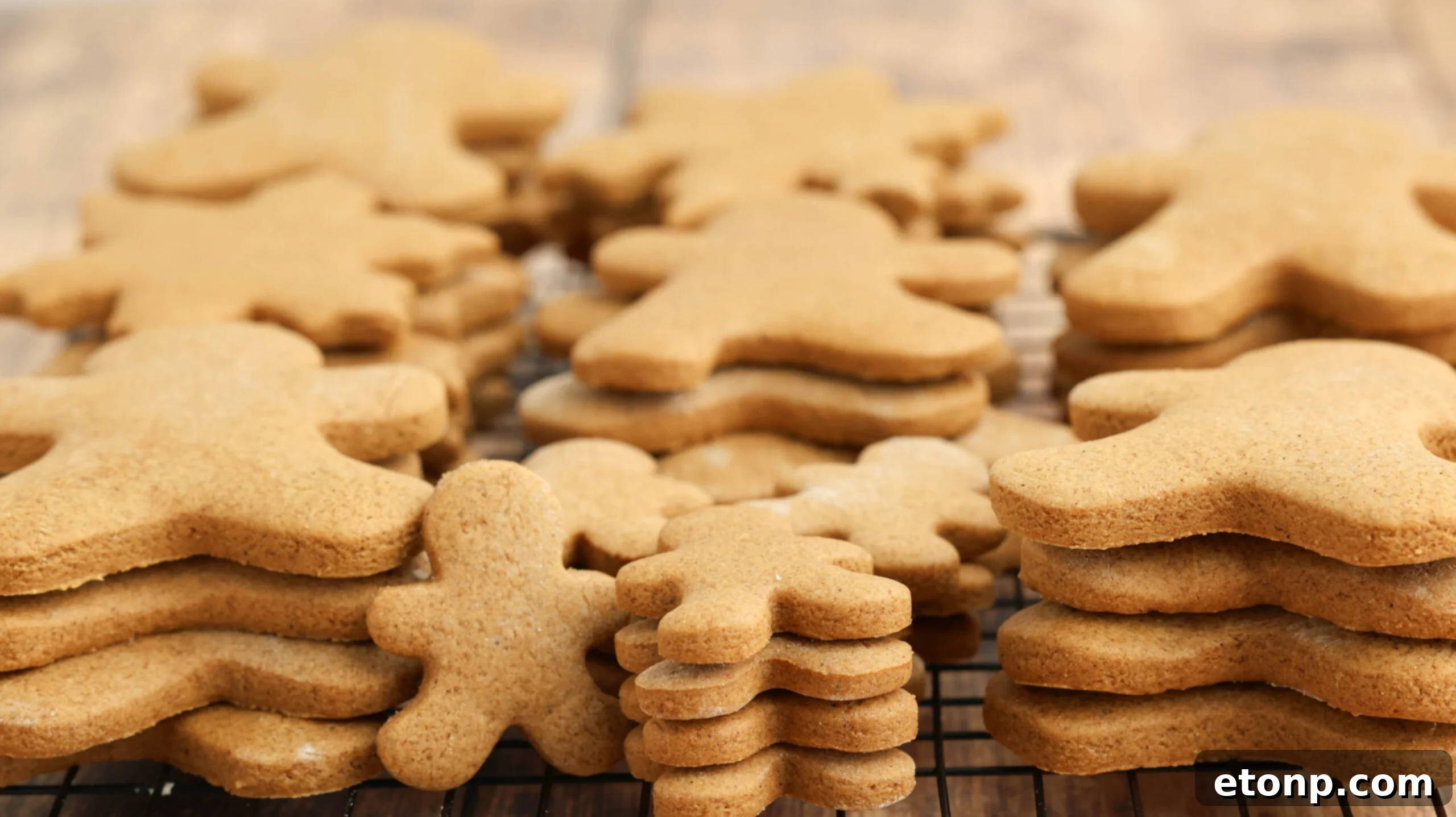Cooling rack filled with stacked Christmas gingerbread cookies waiting to be decorated.