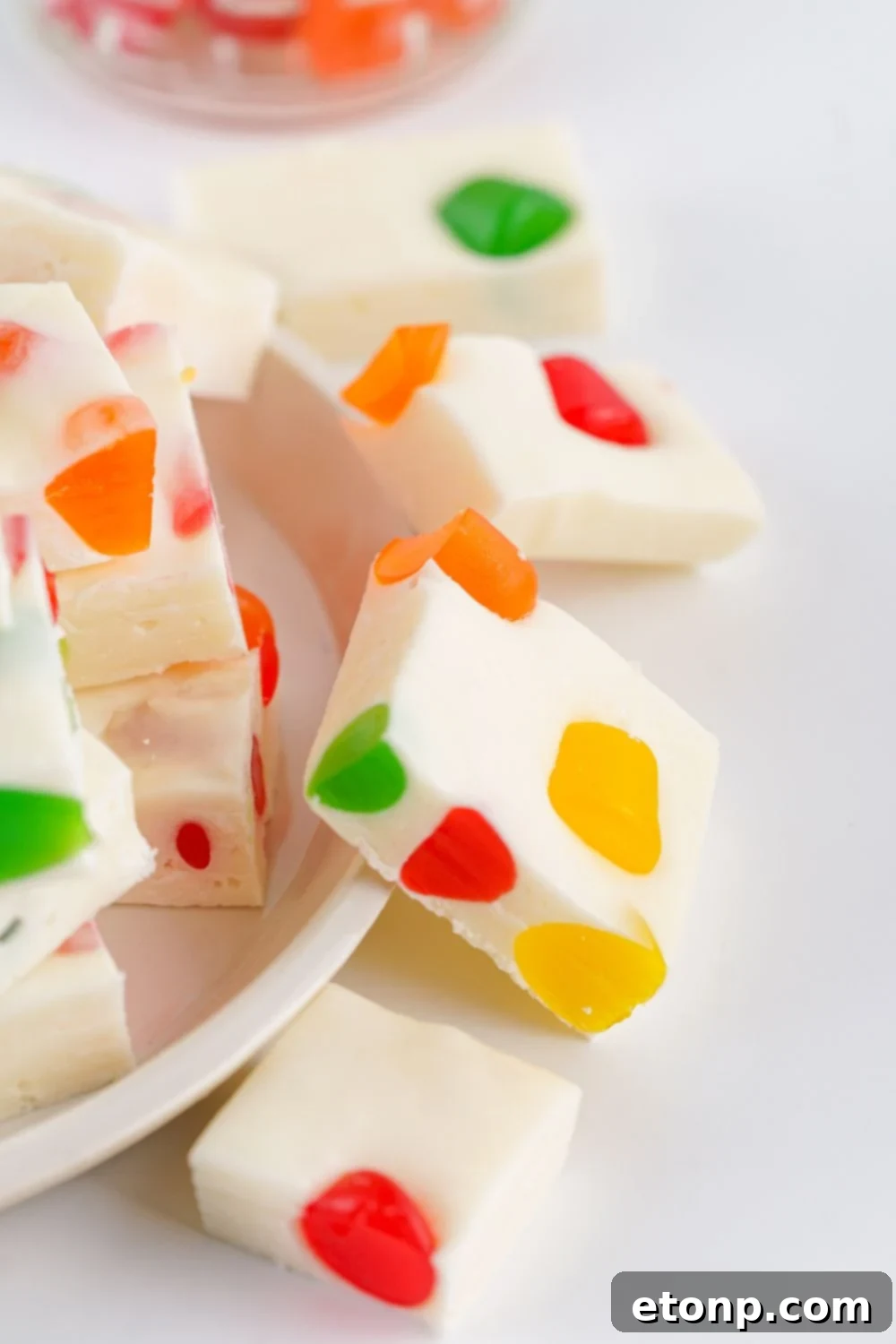 Holiday Gumdrop Nougat: A Nostalgic Christmas Treat 11 A white plate with sliced Christmas Gumdrop Nougat Candy