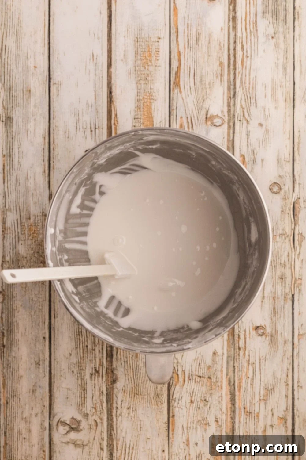 Adorned Sugar Cookies: Soft, Shapely, and Icing-Ready 15 Royal icing being mixed in a metal bowl.