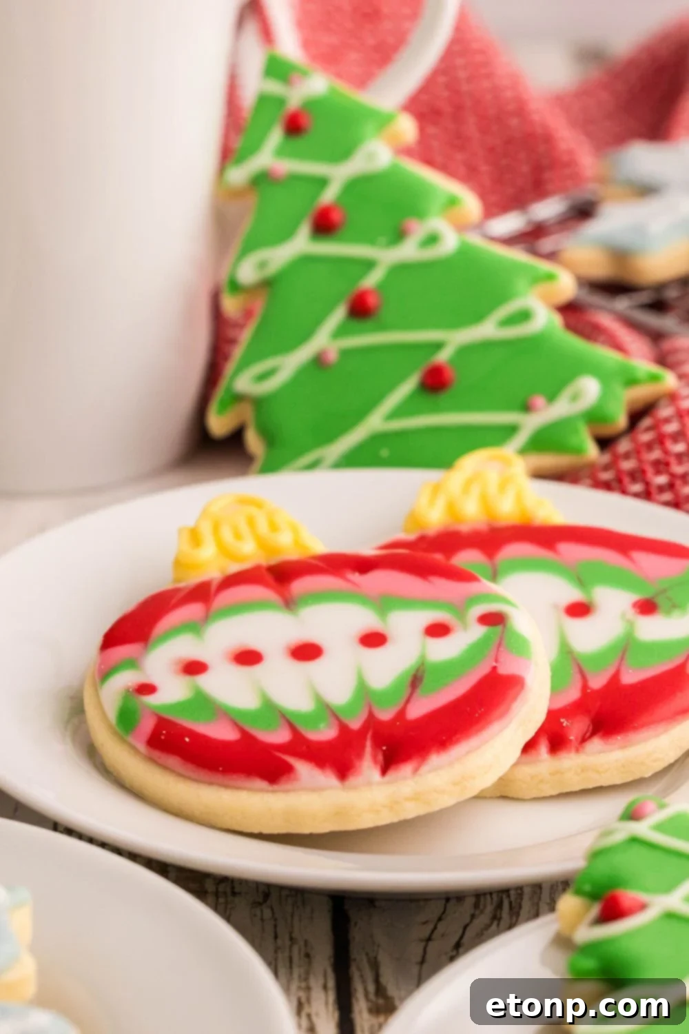 Adorned Sugar Cookies: Soft, Shapely, and Icing-Ready 3 Tall glass of milk with Decorated Sugar Cookies and Christmas ornament cookies.